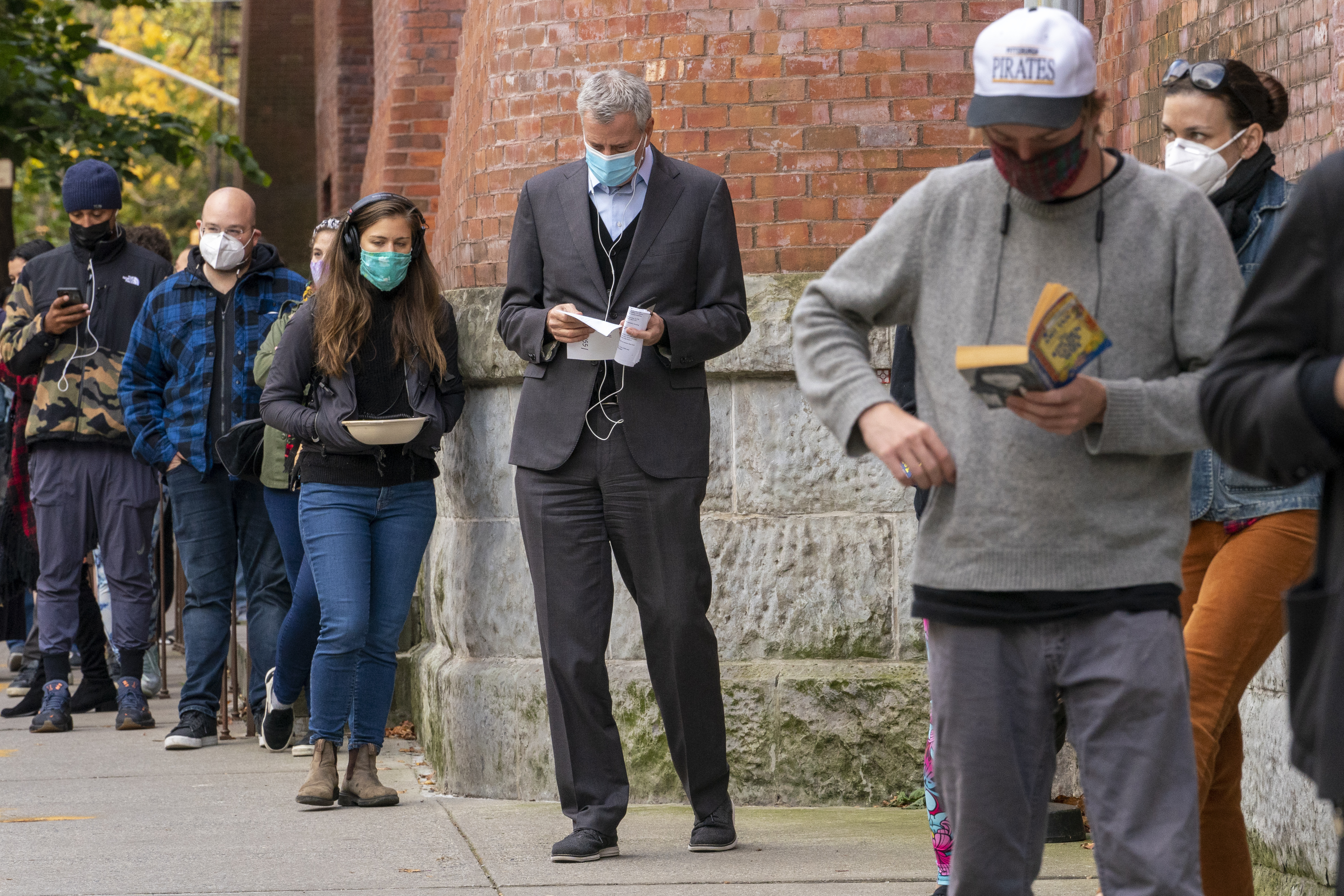 New York Mayor Bill de Blasio, center, stands in line to cast his early vote at the Park Slope Armory YMCA, Tuesday, Oct. 27, 2020.