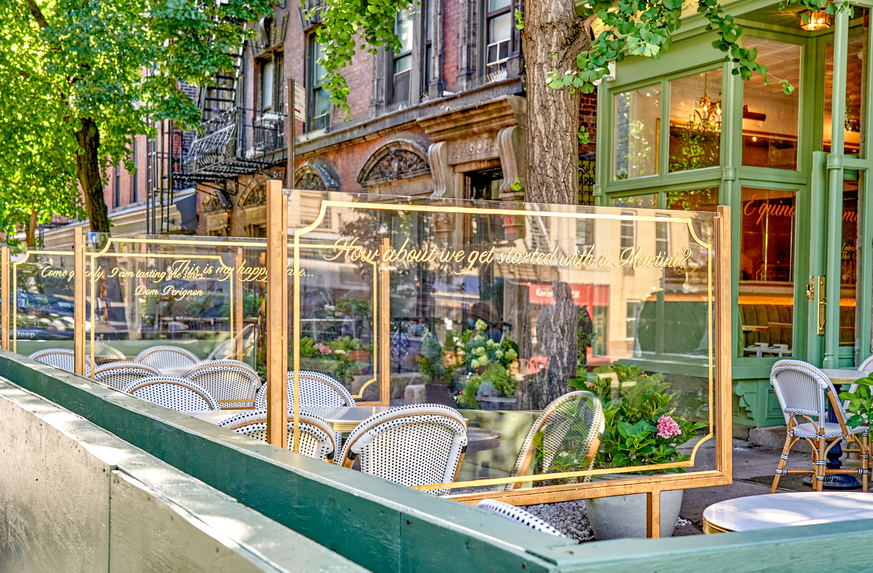 The mint green-colored establishment features outdoor seating along both sides of the facade with curated glass dividers dawning witty cocktail-hour inspired phrases.