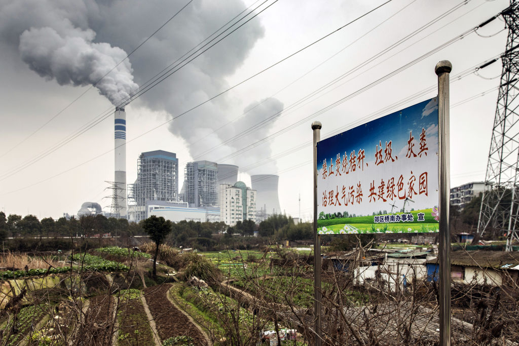 A sign warning residents not to burn trash in order to reduce pollution stands not far from a coal-fired power station in Tongling, Anhui province, China, on Jan. 16, 2019. 