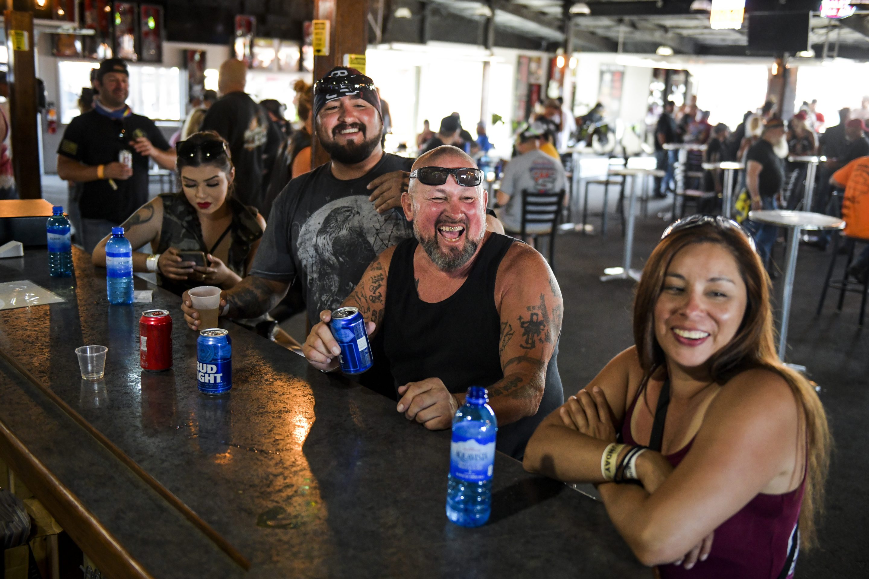 Tonio Mondragon, second from left, Anthony Mondragon, second from right, and Cecily Romero, right, laugh while drinking at the Big Engine Bar at the Buffalo Chip during the 80th Annual Sturgis Motorcycle Rally in Sturgis, South Dakota on August 9, 2020. Michael Ciaglo—Getty Images