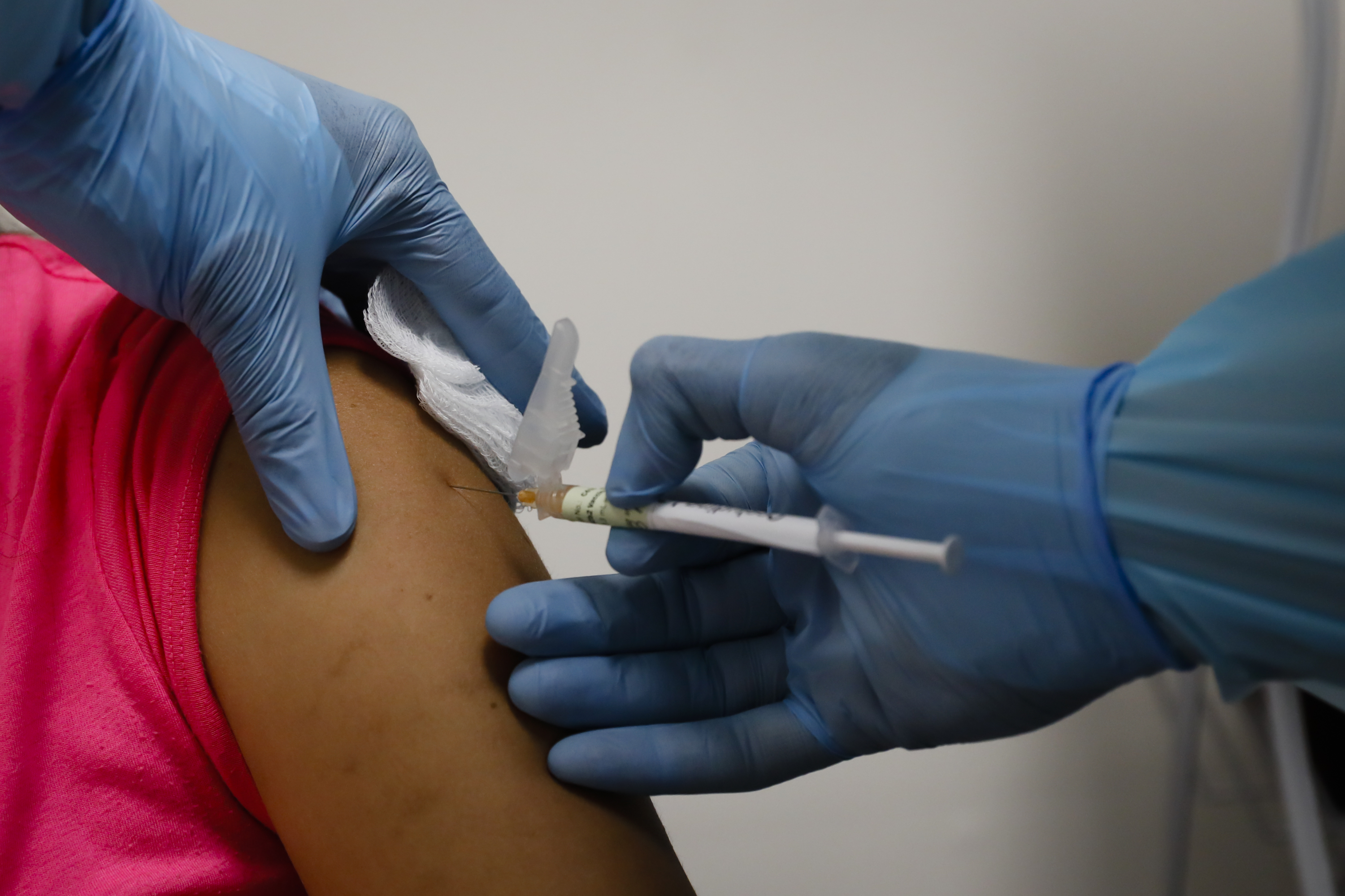 A health worker injects a woman during clinical trials for a Covid-19 vaccine at Research Centers of America in Hollywood, Florida, U.S., on Wednesday, Sept. 9, 2020. Drugmakers racing to produce Covid-19 vaccines pledged to avoid shortcuts on science as they face pressure to rush a shot to market. Photographer: Eva Marie Uzcategui/Bloomberg via Getty Images