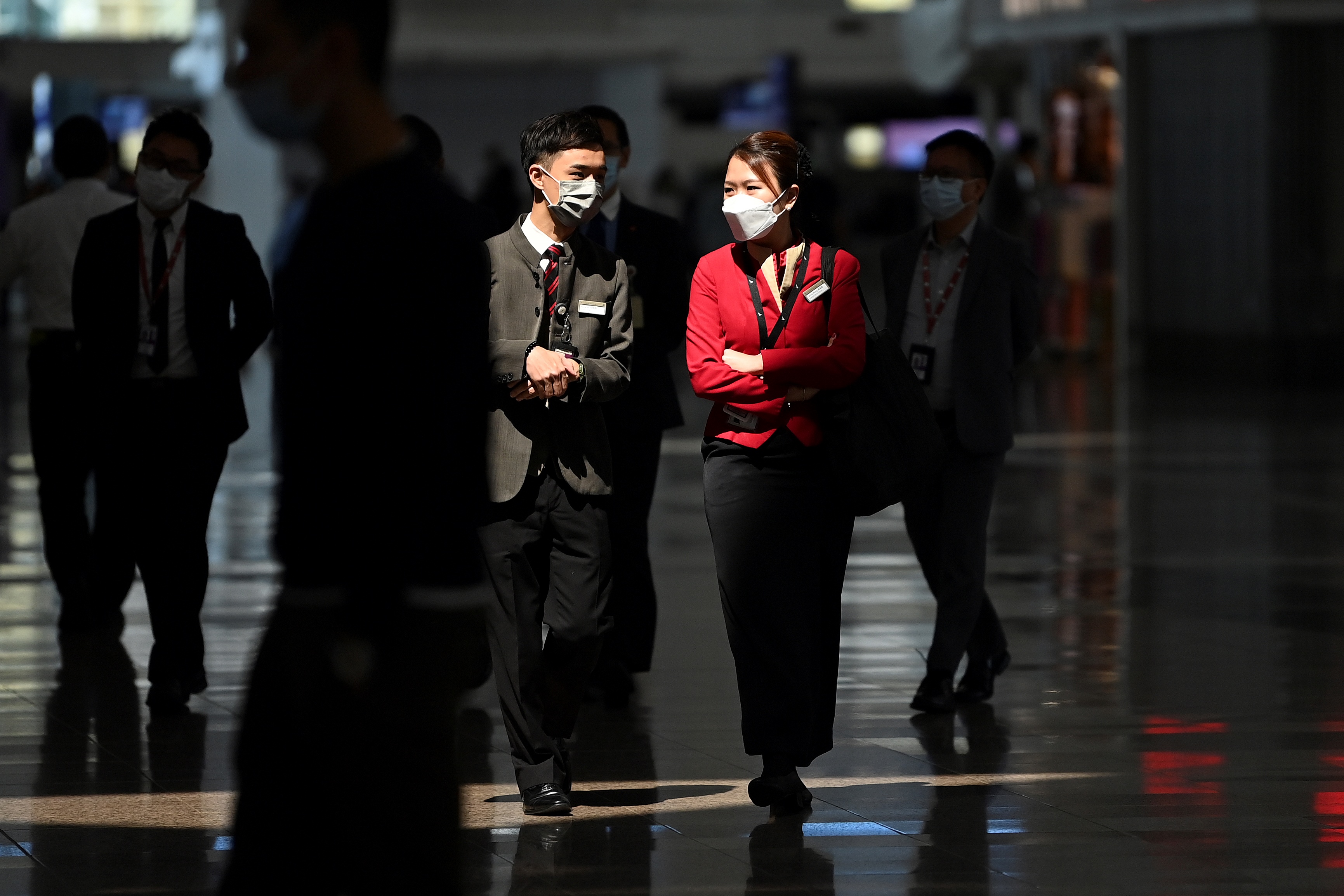 Cathay Pacific employees walk through Hong Kong International Airport on Oct. 21, 2020, after the flag carrier airline announced that 6,000 staff would lose their jobs owing to the COVID-19 pandemic.