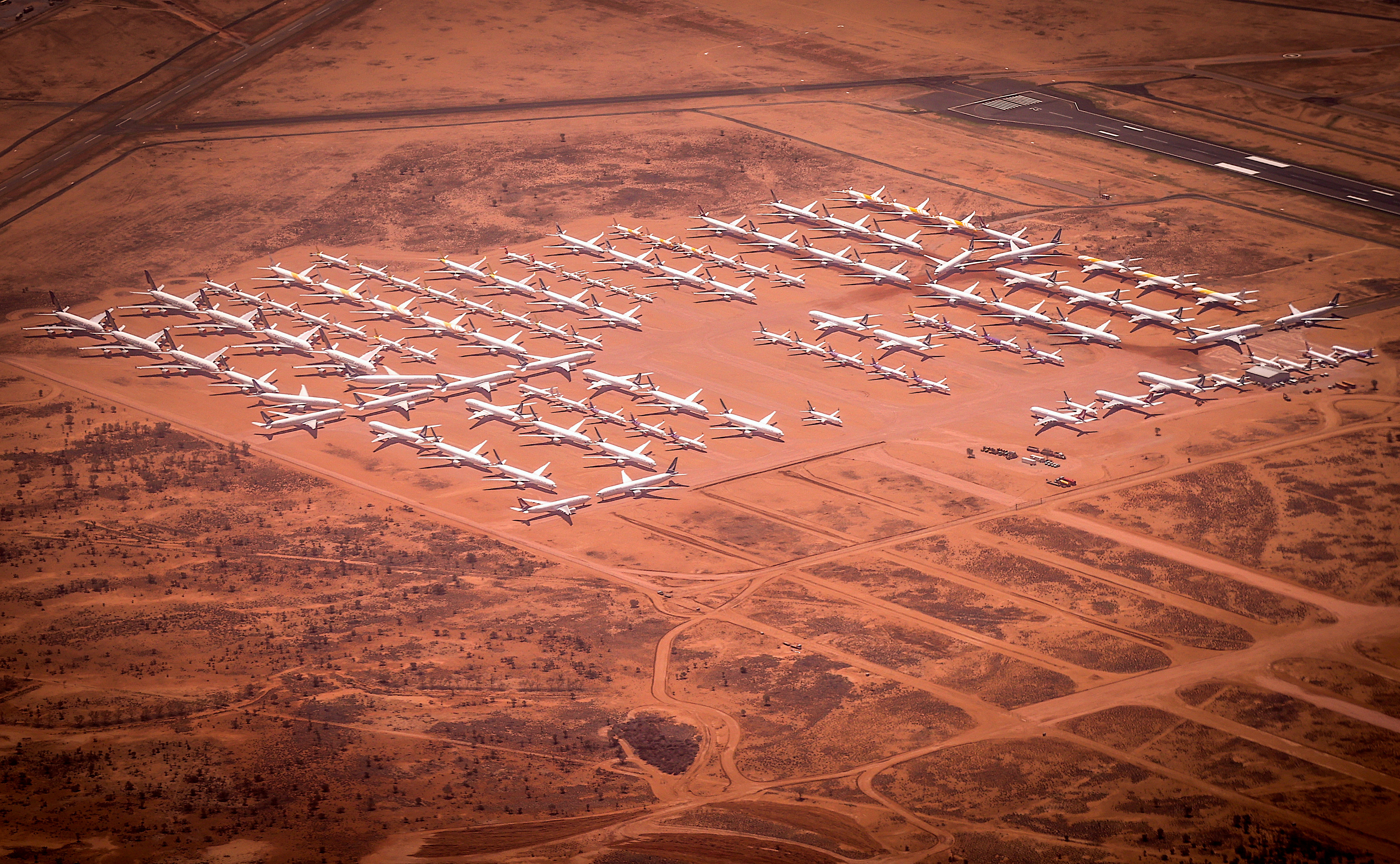 Aircraft are stored at the Asia Pacific Aircraft Storage Facility (APAS) in Alice Springs, Northern Territory, Australia, on Friday, Oct. 23, 2020. The APAS facility makes a strange and eerie sight, with the flat landscape punctuated by familiar tall tail fins against a brooding desert sky. More than 100 Aircraft are stored at the purpose-built facility adjacent to the airport, which can keep jets maintained and ready to be brought back into service when needed. Photographer: David Gray/Bloomberg via Getty Images