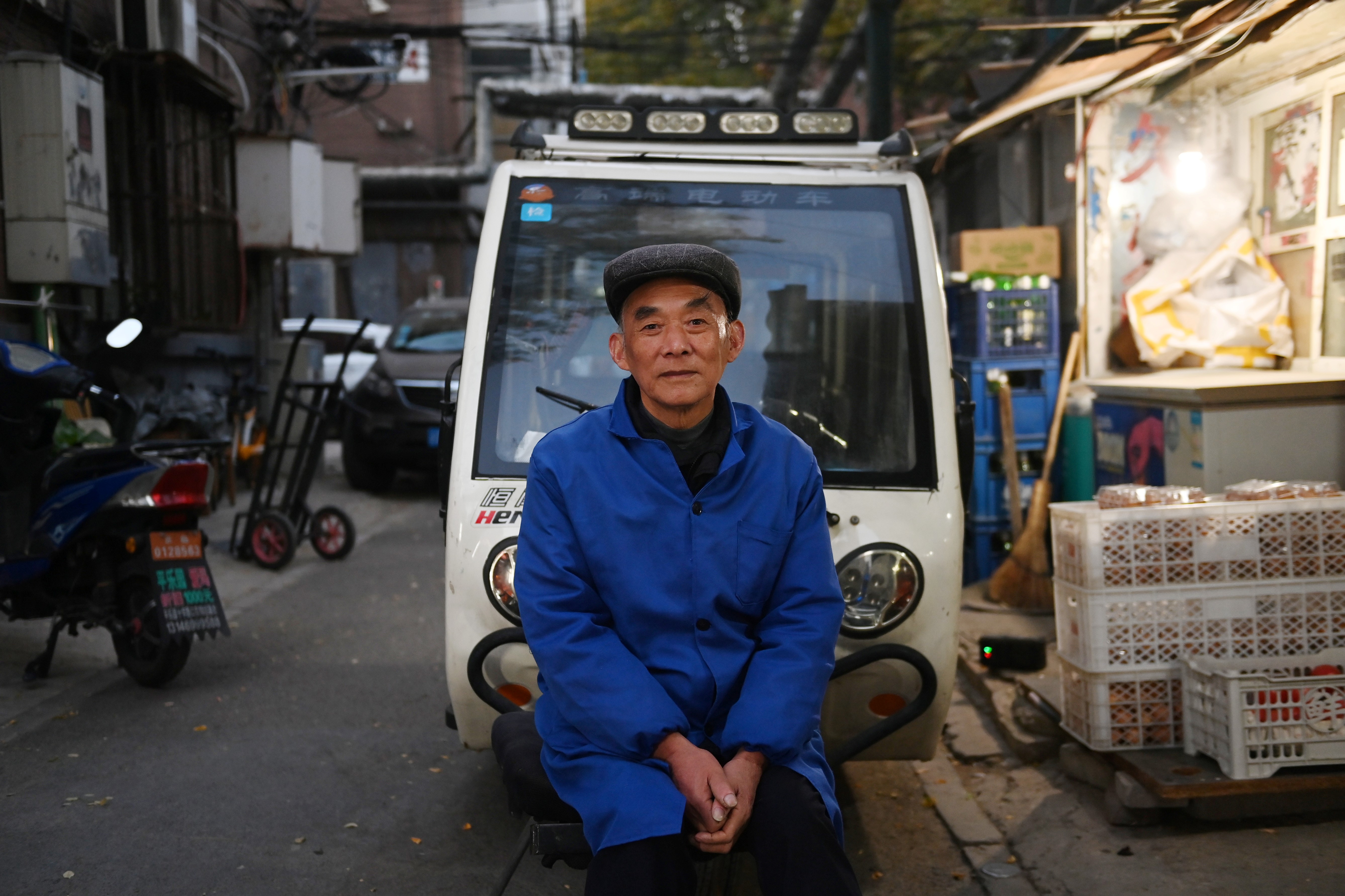 A man sits outside a food market in Beijing on October 29, 2020. - China's Communist leadership laid out broad plans for the next five years on October 29, outlining an economic future centred on stronger domestic spending -- but not committing to a targeted speed of growth. (Photo by GREG BAKER / AFP) (Photo by GREG BAKER/AFP via Getty Images)