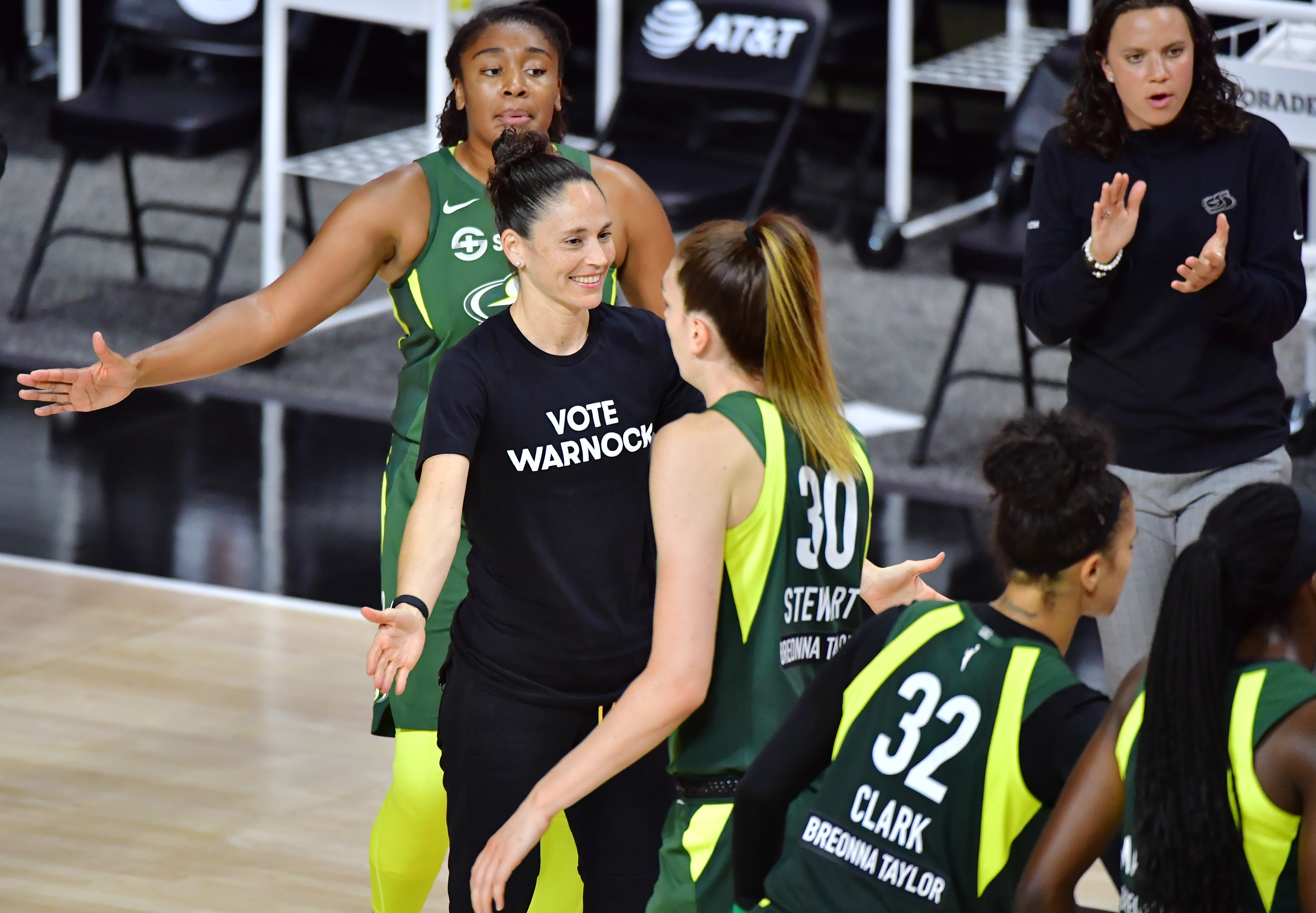 Sue Bird #10 of the Seattle Storm low fives Breanna Stewart #30 while wearing a Vote Warnock T-shirt during the second half of a game against the Connecticut Sun at Feld Entertainment Center on August 04, 2020 in Palmetto, Florida. NOTE TO USER: User expressly acknowledges and agrees that, by downloading and or using this photograph, User is consenting to the terms and conditions of the Getty Images License Agreement. (Photo by Julio Aguilar/Getty Images)