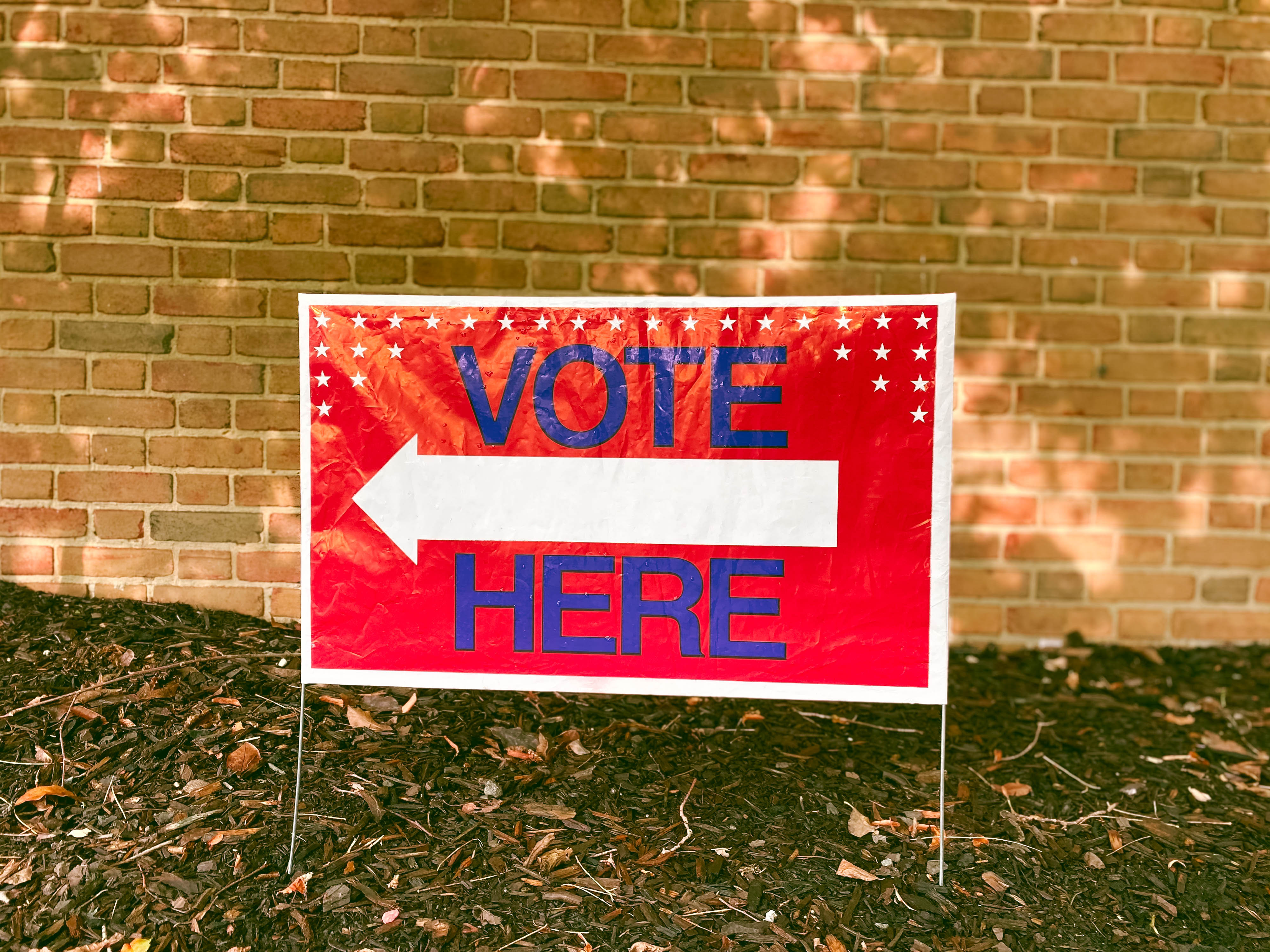 Close-up of "Vote Here" sign outside of polling place.