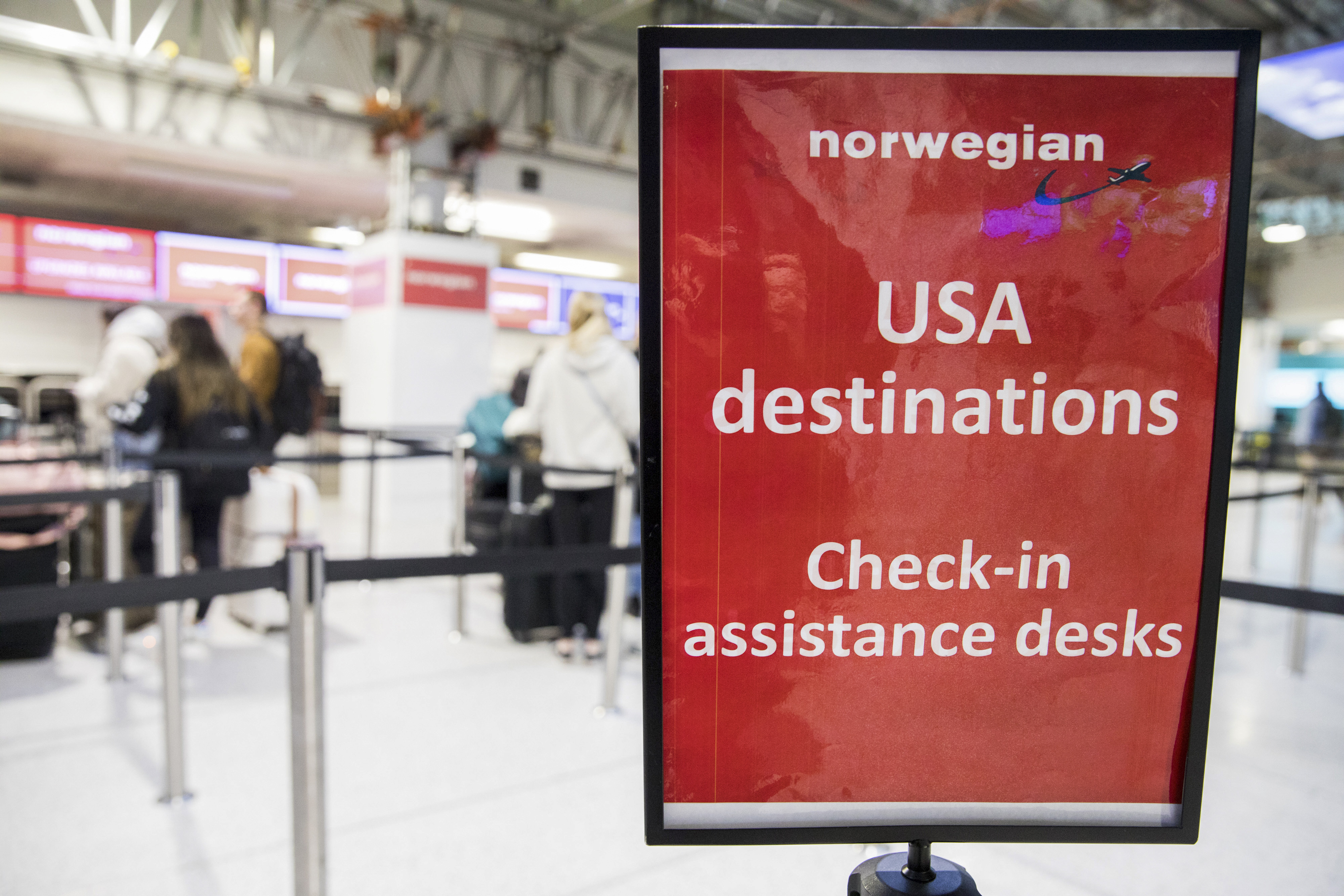 A sign stands at the check-in area for flights to the U.S. with Norwegian Air Shuttle ASA at Gatwick Airport in Crawley, U.K., on Friday, Feb. 13, 2020. Norwegian Air is suspending thousands of flights and slashing its workforce in response to the fallout of the coronavirus and the widespread travel restrictions its triggered. Photographer: Chris Ratcliffe/Bloomberg via Getty Images