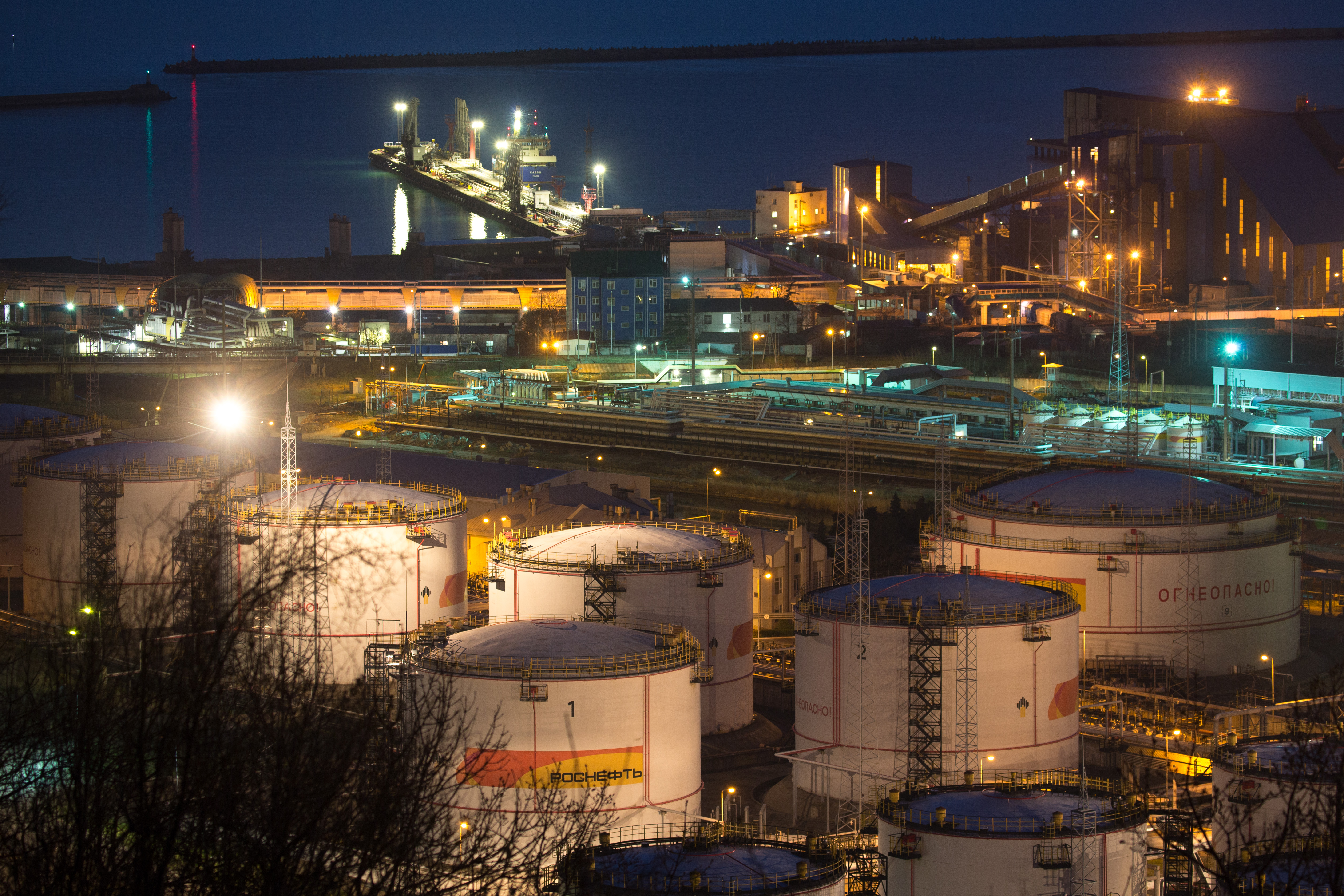 Oil storage tanks stand illuminated at night at the RN-Tuapsinsky refinery, operated by Rosneft Oil Co., in Tuapse, Russia, on Sunday, March 22, 2020.