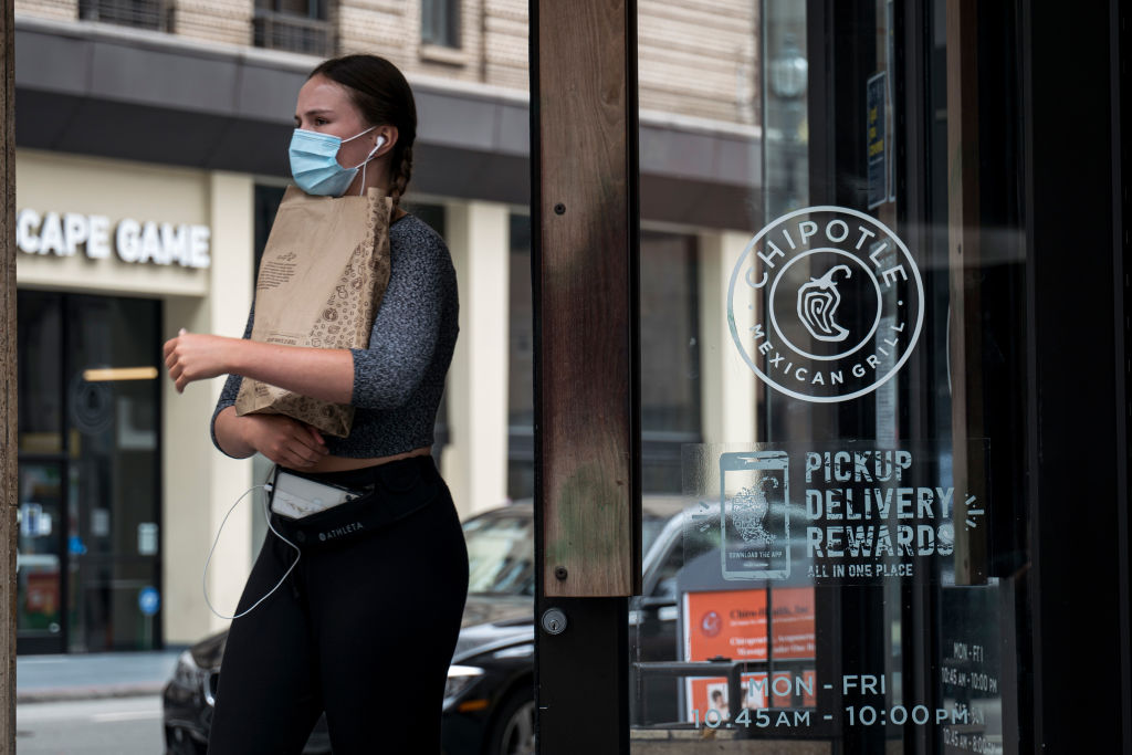 A customer wearing a protective mask exits a Chipotle Mexican Grill Inc. restaurant in San Francisco, California, U.S., on Monday, July 20, 2020.