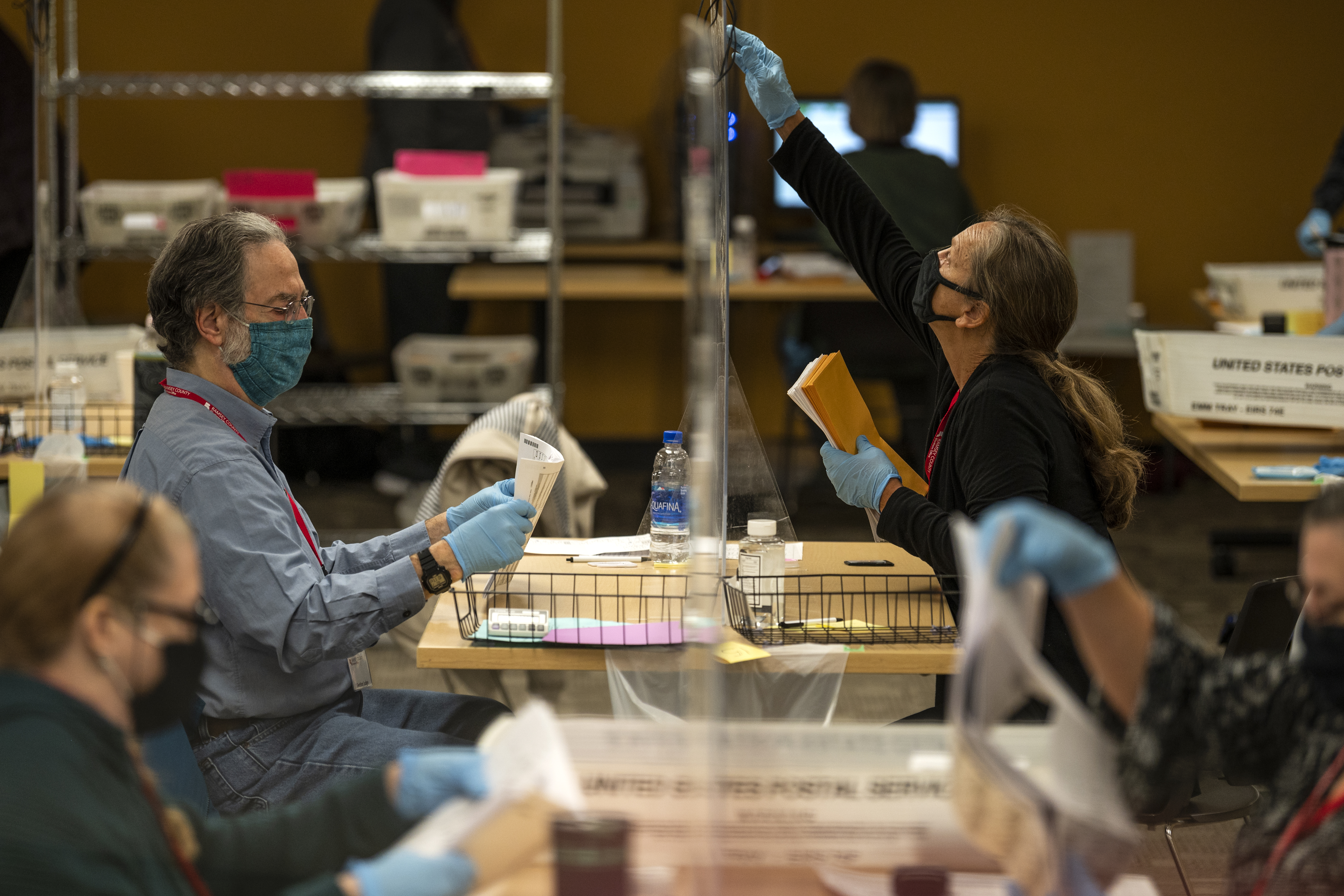 Volunteers and election officials process absentee ballots at Ramsey County's absentee ballot count center on November 2, 2020 in St Paul, Minn.