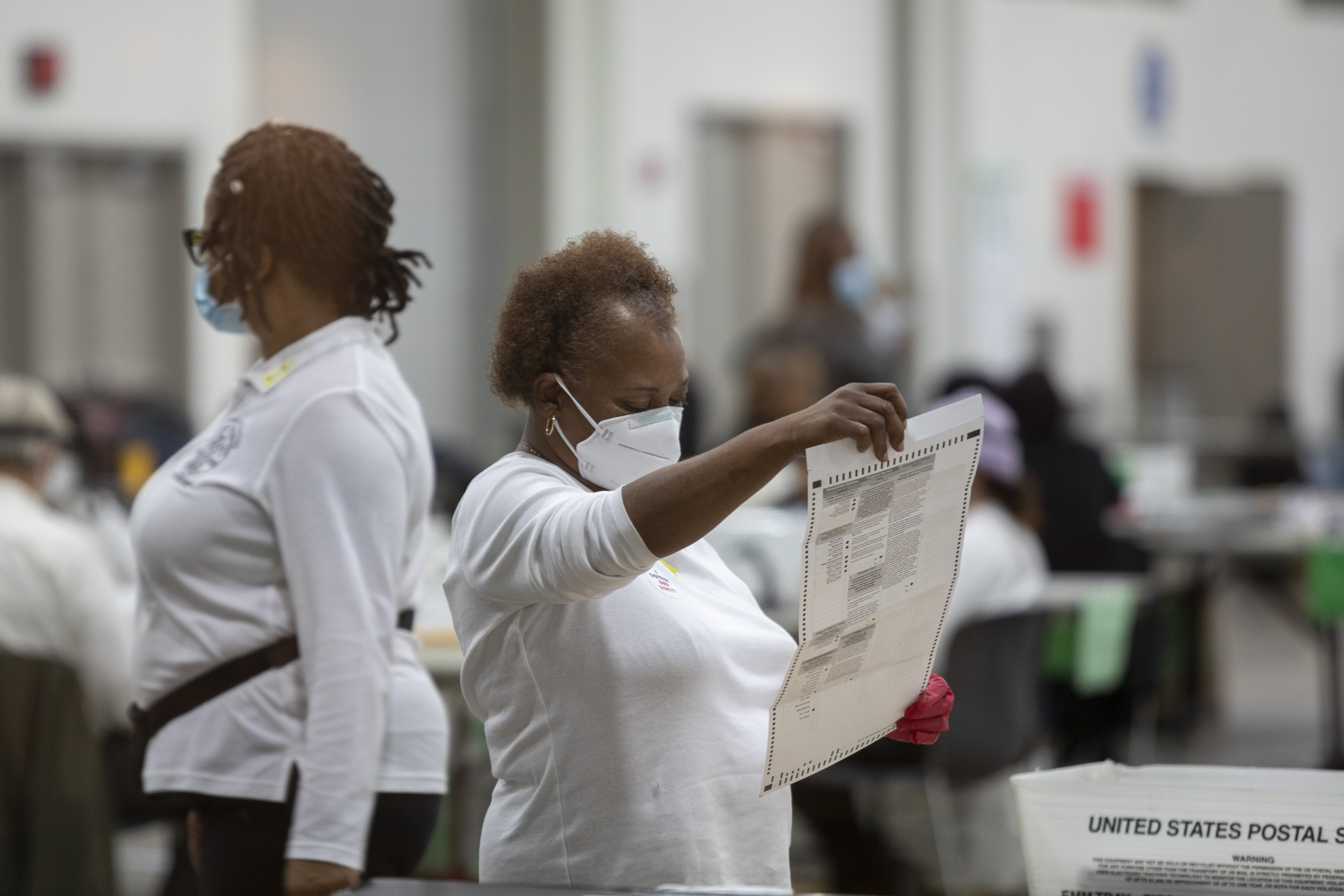 A worker with the Detroit Department of Elections inspects an absentee ballot at the Central Counting Board in the TCF Center on November 4, 2020 in Detroit, Michigan. 