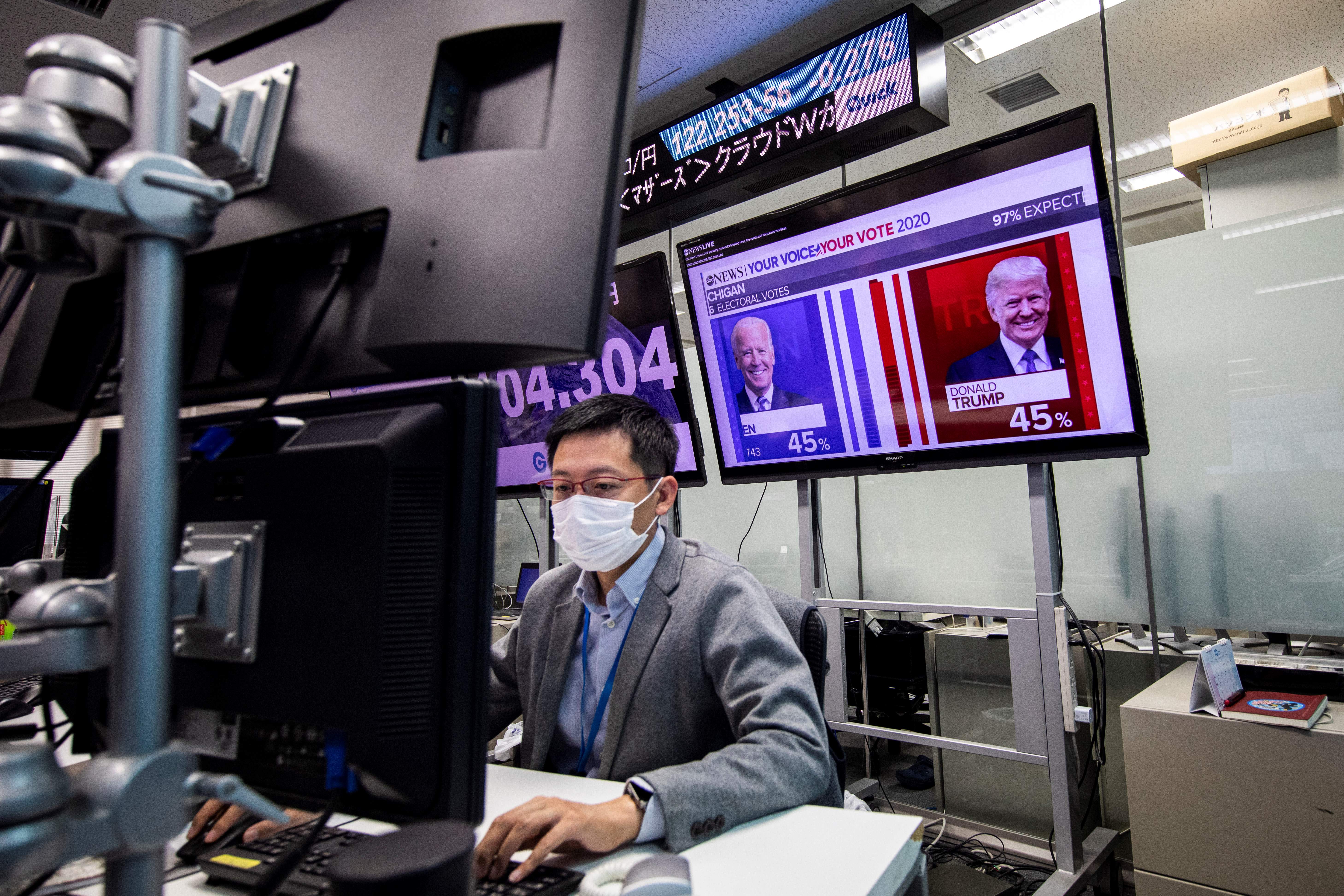 A currency trader in Tokyo keeps tabs on the U.S. election results.