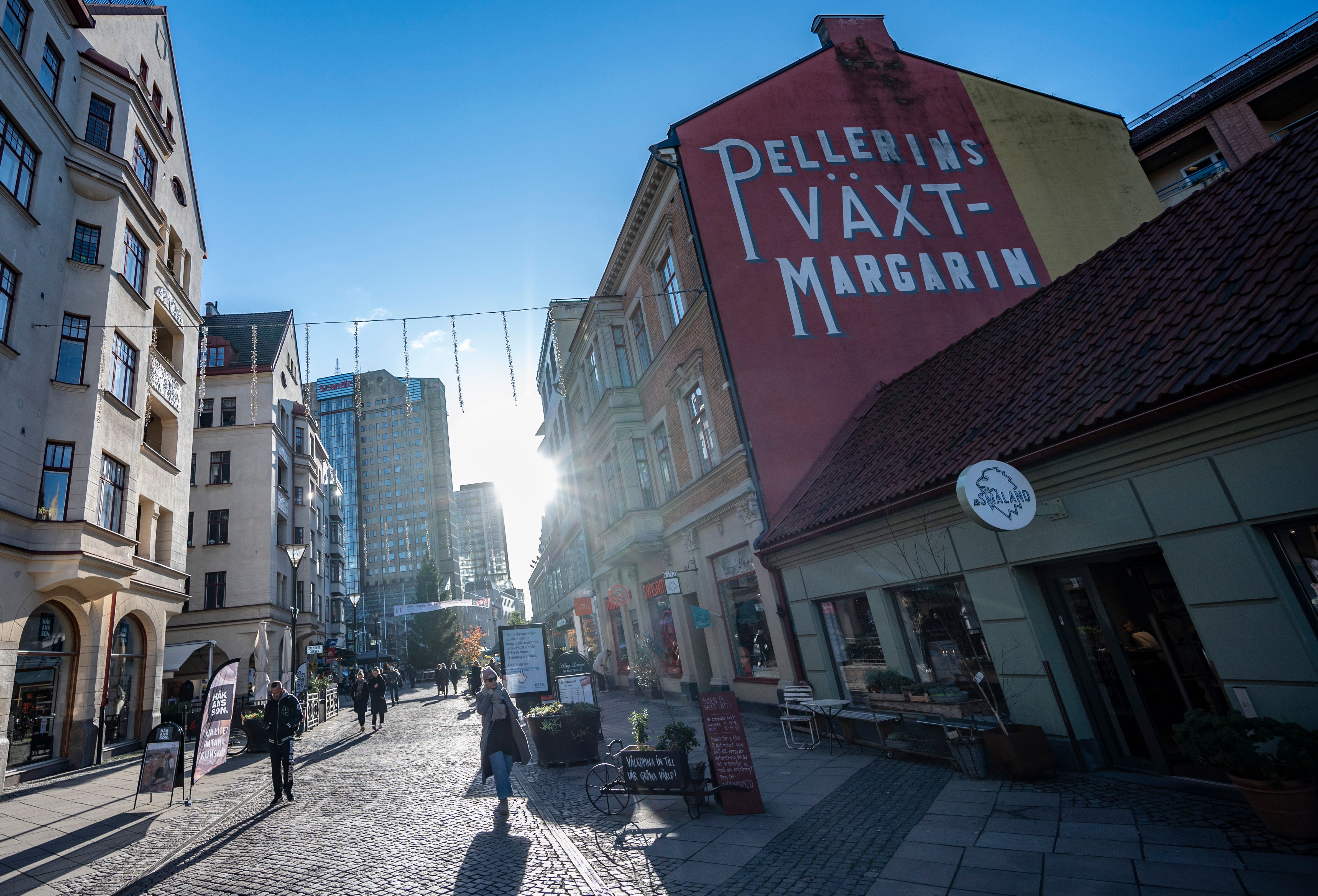 People stroll in the cold but sunny weather in a pedestrian street in Malmö, southern Sweden, on November 20, 2020, amid the ongoing coronavirus pandemic.