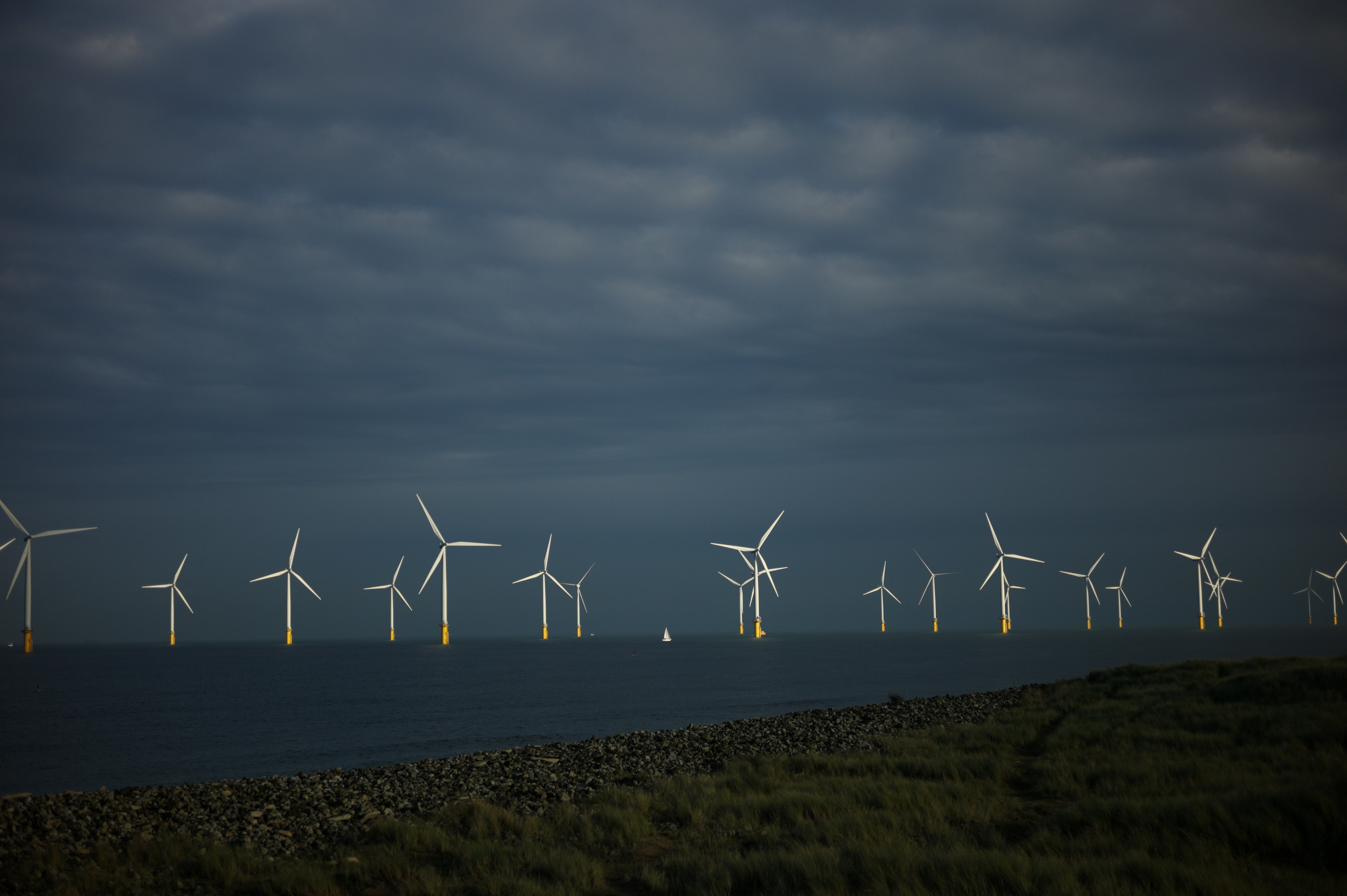 A small sailing boat passes the EDF energy offshore wind farm near Redcar on November 25, 2020 in Redcar, England. The U.K. already leads the world in offshore wind production. Now, it will be host to the world's largest ever wind farm.