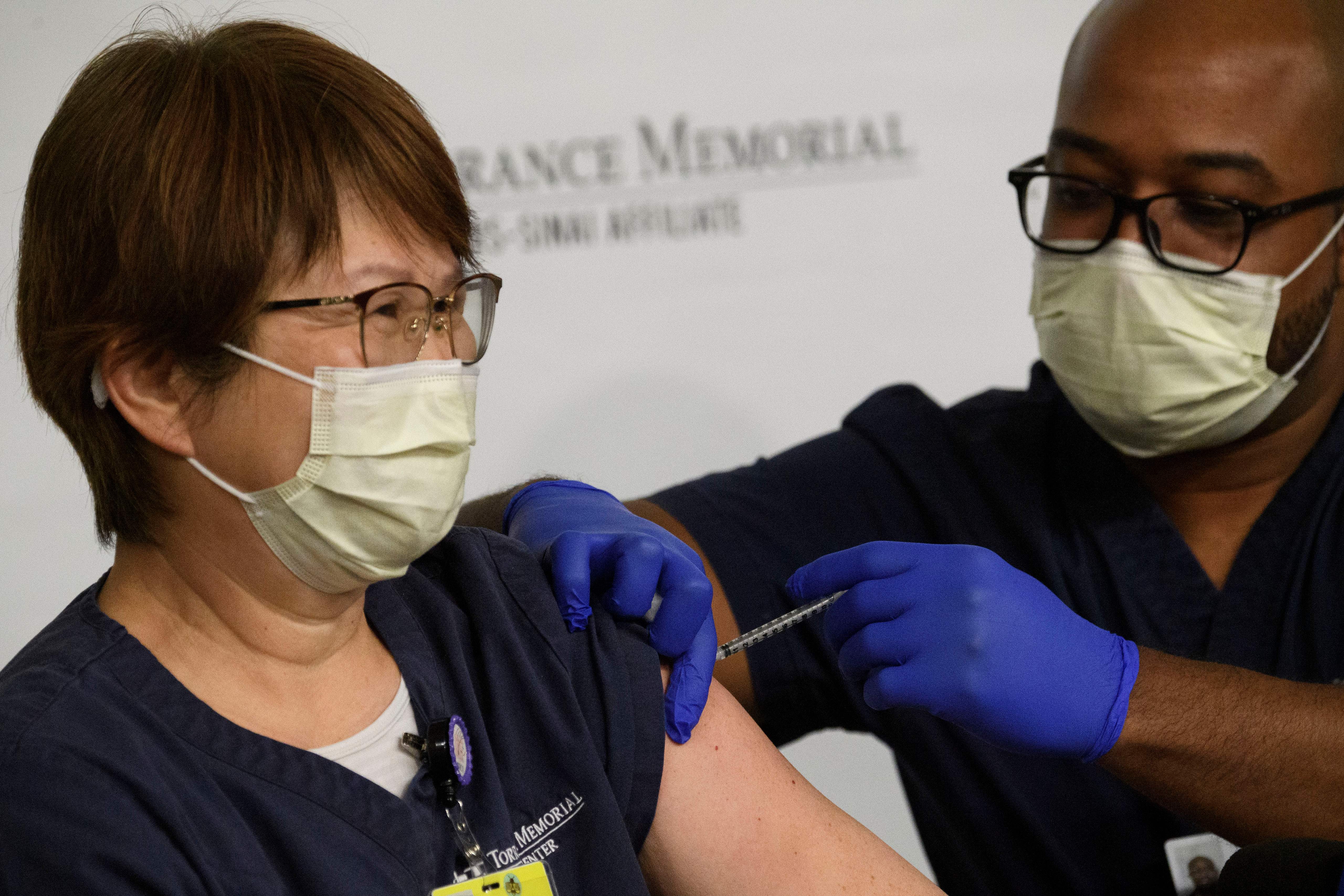 A nurse receives a dose of Pfizer and BioNTech’s COVID-19 vaccine in Torrance, Calif., on Dec. 19. Torrance is located in Los Angeles County, which has partnered with health notification platform Healthvana to remind patients to return for the required second dose.