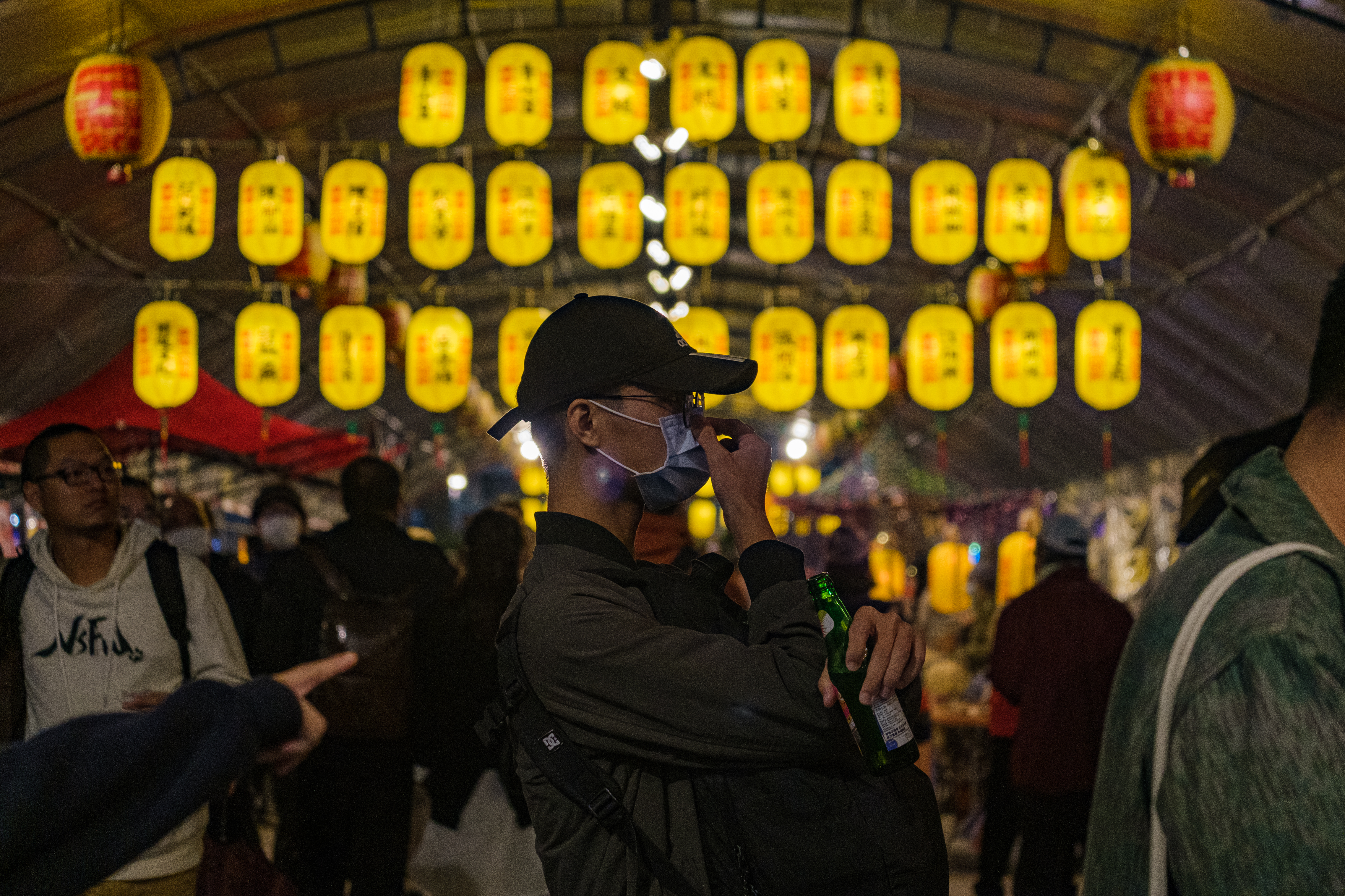 A man wearing a face mask walk by lanterns in Wanhua, Taipei, Taiwan on December 05, 2020. The island's COVID-19 streak has ended.