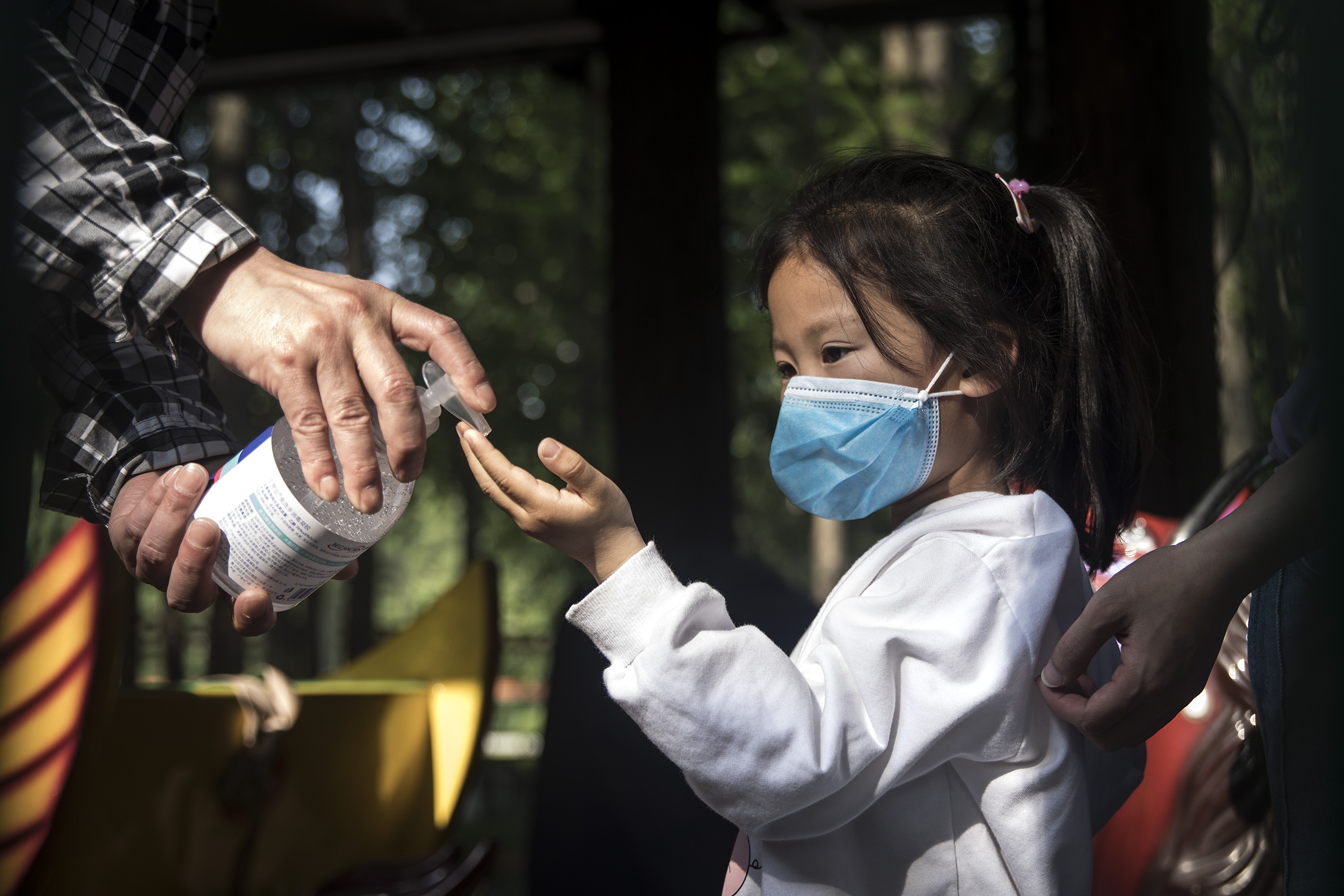An employee gives out hand sanitizer to a girl in Zhongshan Park on April 28, 2020, in Wuhan, China. Scientists have warned that since the pandemic began, there has been a sharp jump in eye injuries in children due to hand sanitizer.