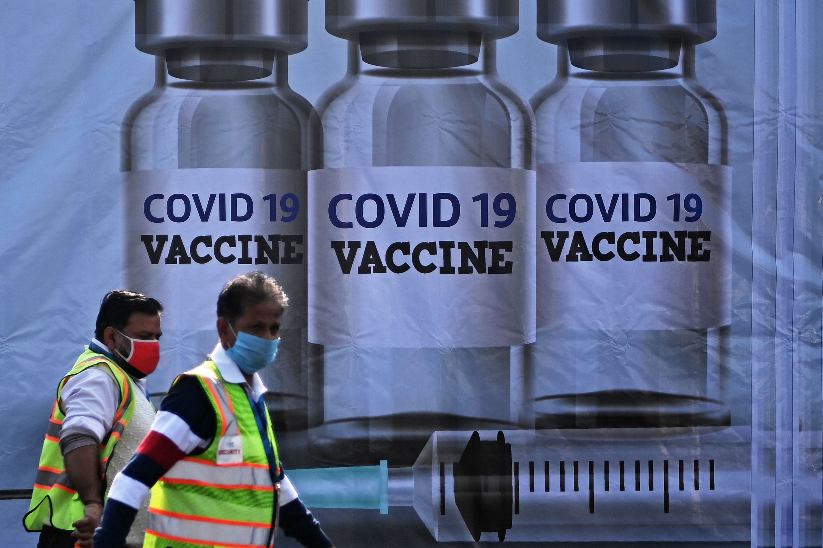 Members of ground staff walk past a container stacked at Cargo Terminal 2 of Indira Gandhi International Airport, which will be used as a handling and distribution center for coronavirus vaccines, in New Delhi on Dec. 22, 2020.