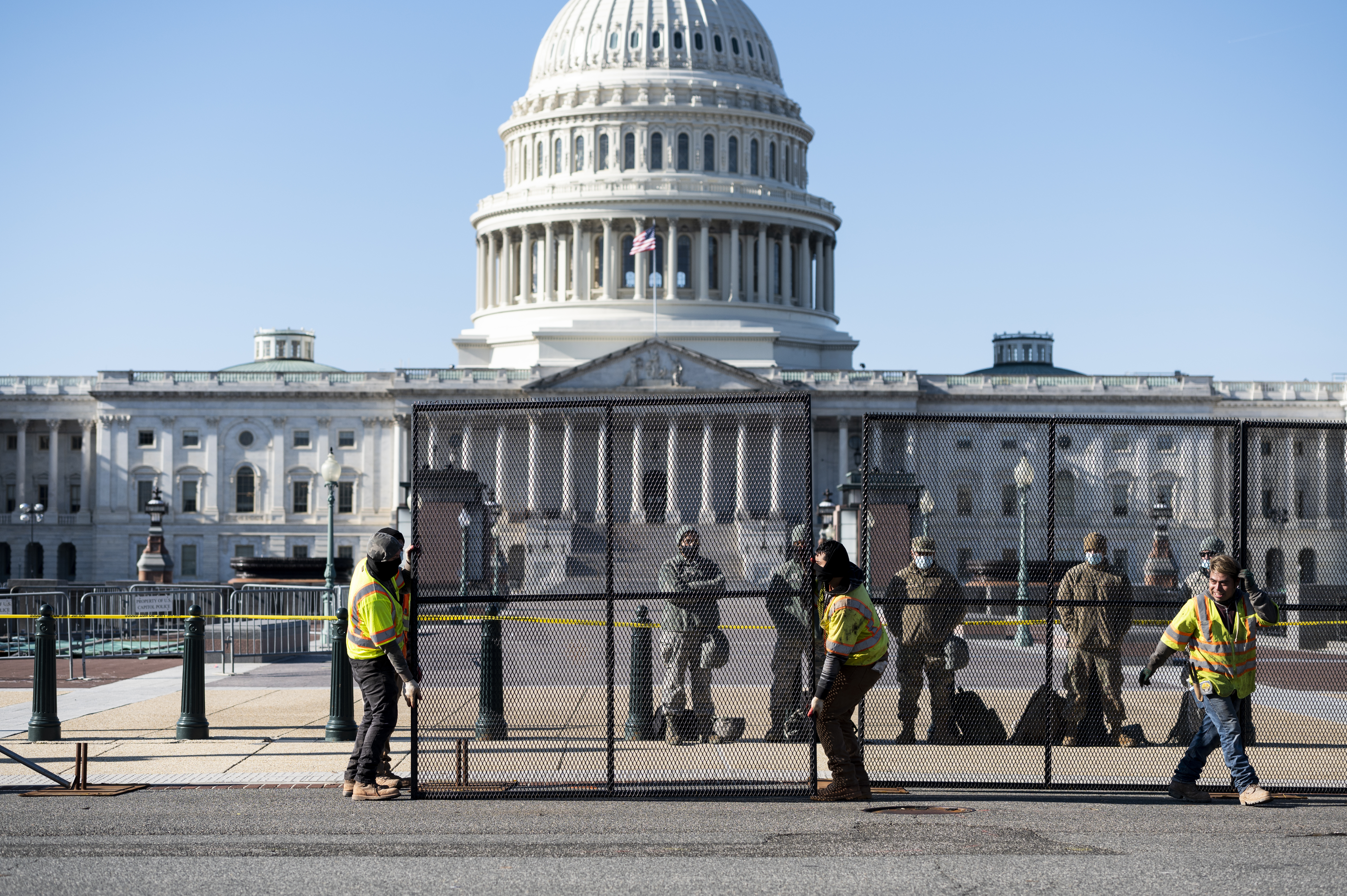 Workers install more robust fencing along the east side of the U.S. Capitol on Thursday morning.