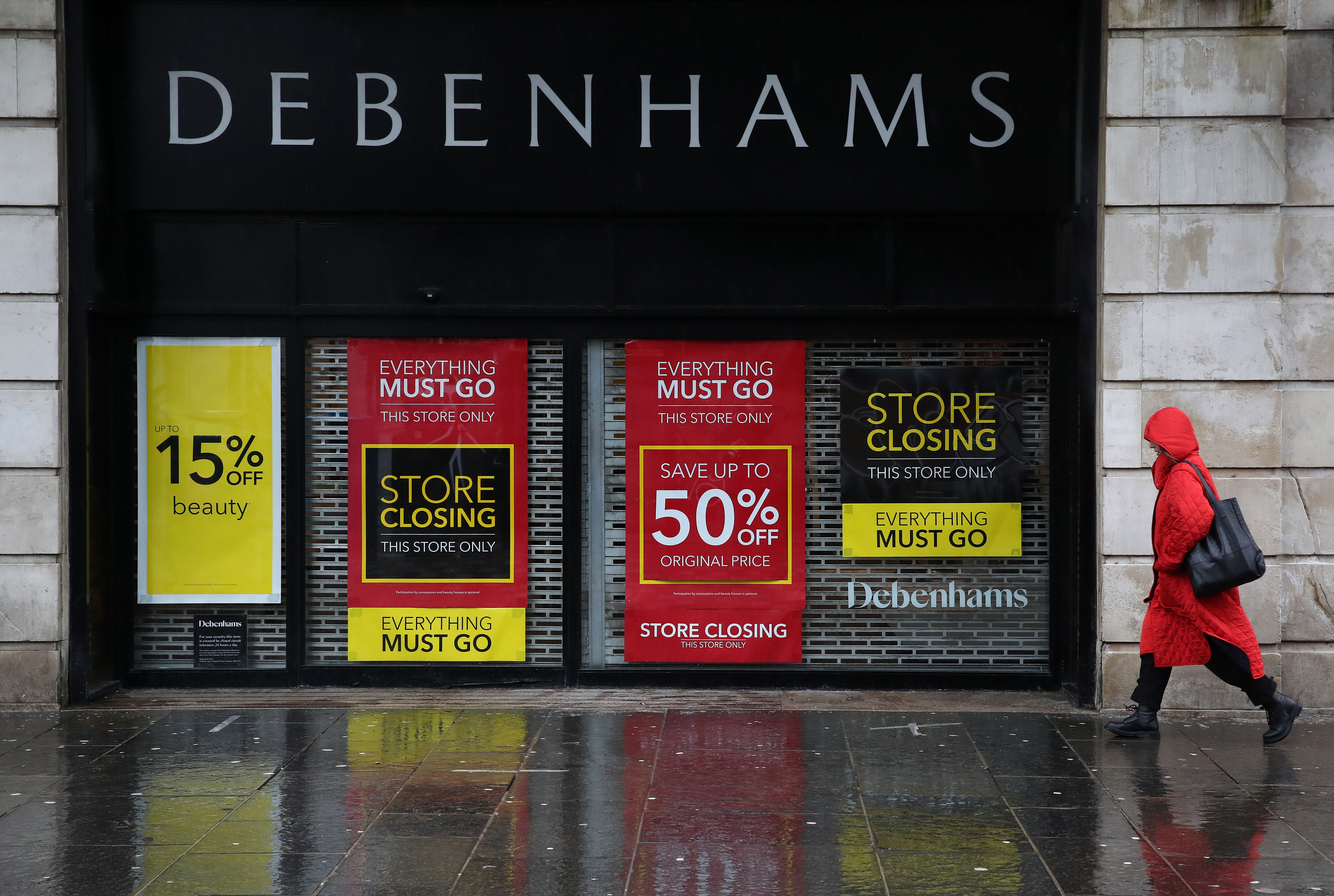 A person walks passed a Debenhams store in Glasgow. The brand will be taken over by Boohoo, an e-commerce brand.