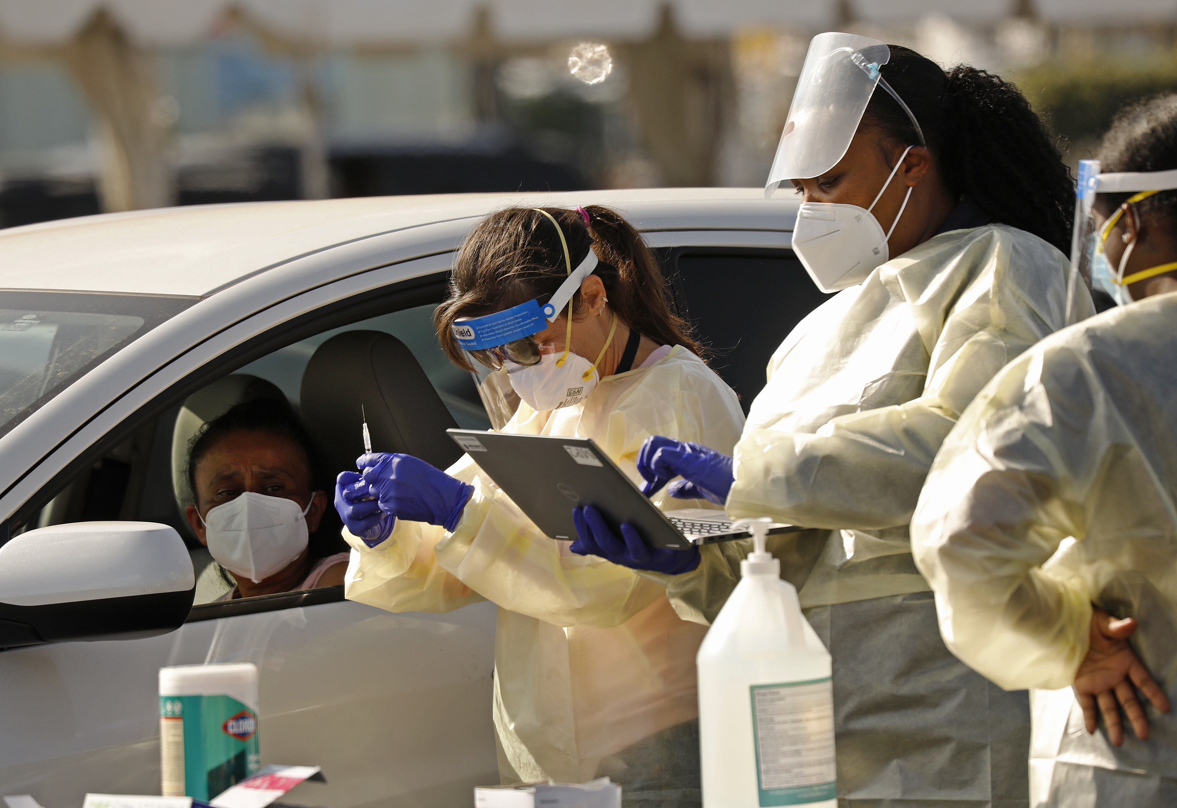 Staff and volunteers distribute the COVID-19 vaccine at a mass-vaccination site in Los Angeles. To get the rollout right, writes Oliver Kharraz, “We should allow all qualified providers, regardless of specialty, to administer the vaccine.”