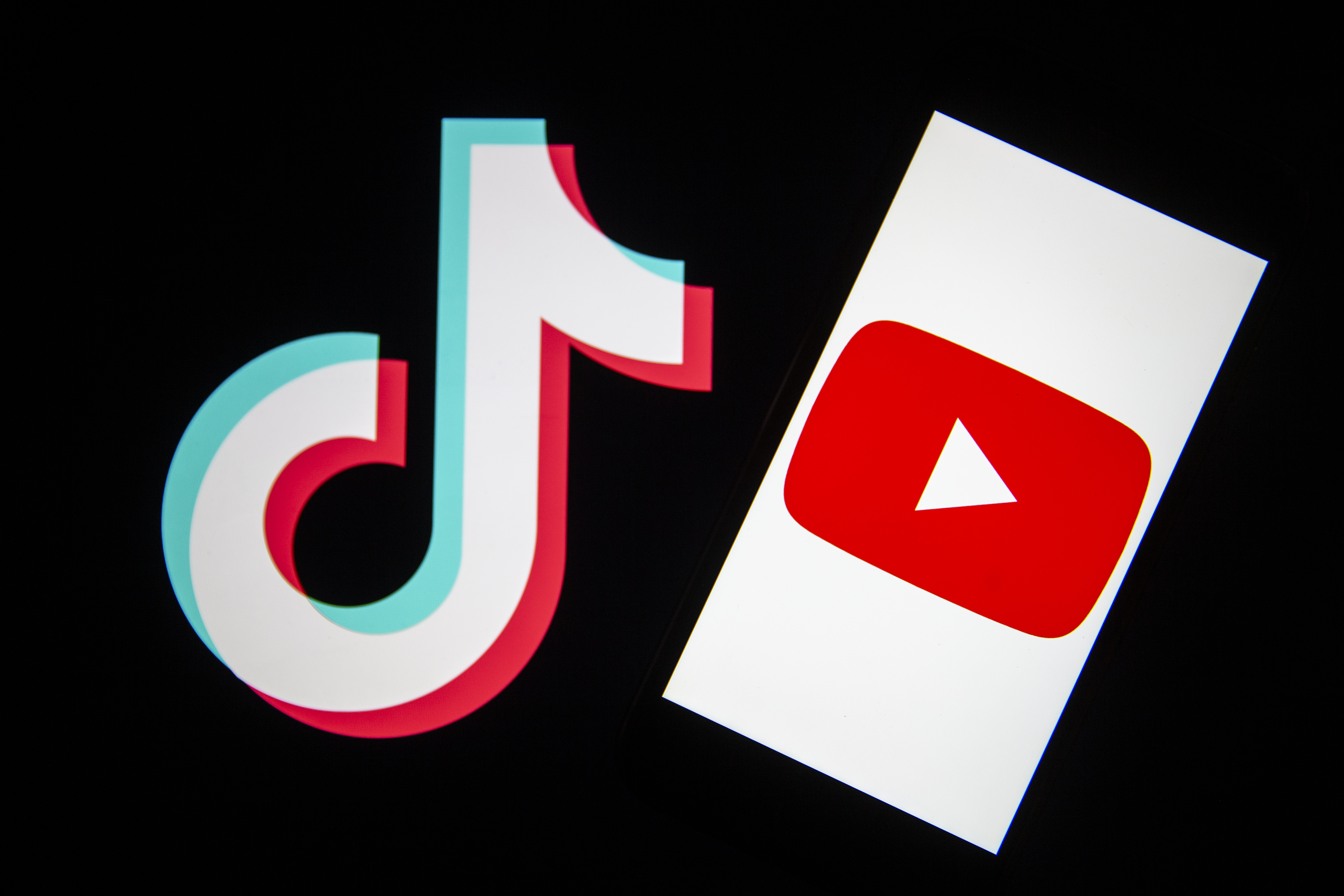 In this photo illustration, a mobile phone screen displays the logo of Youtube near the logo of TikTok.