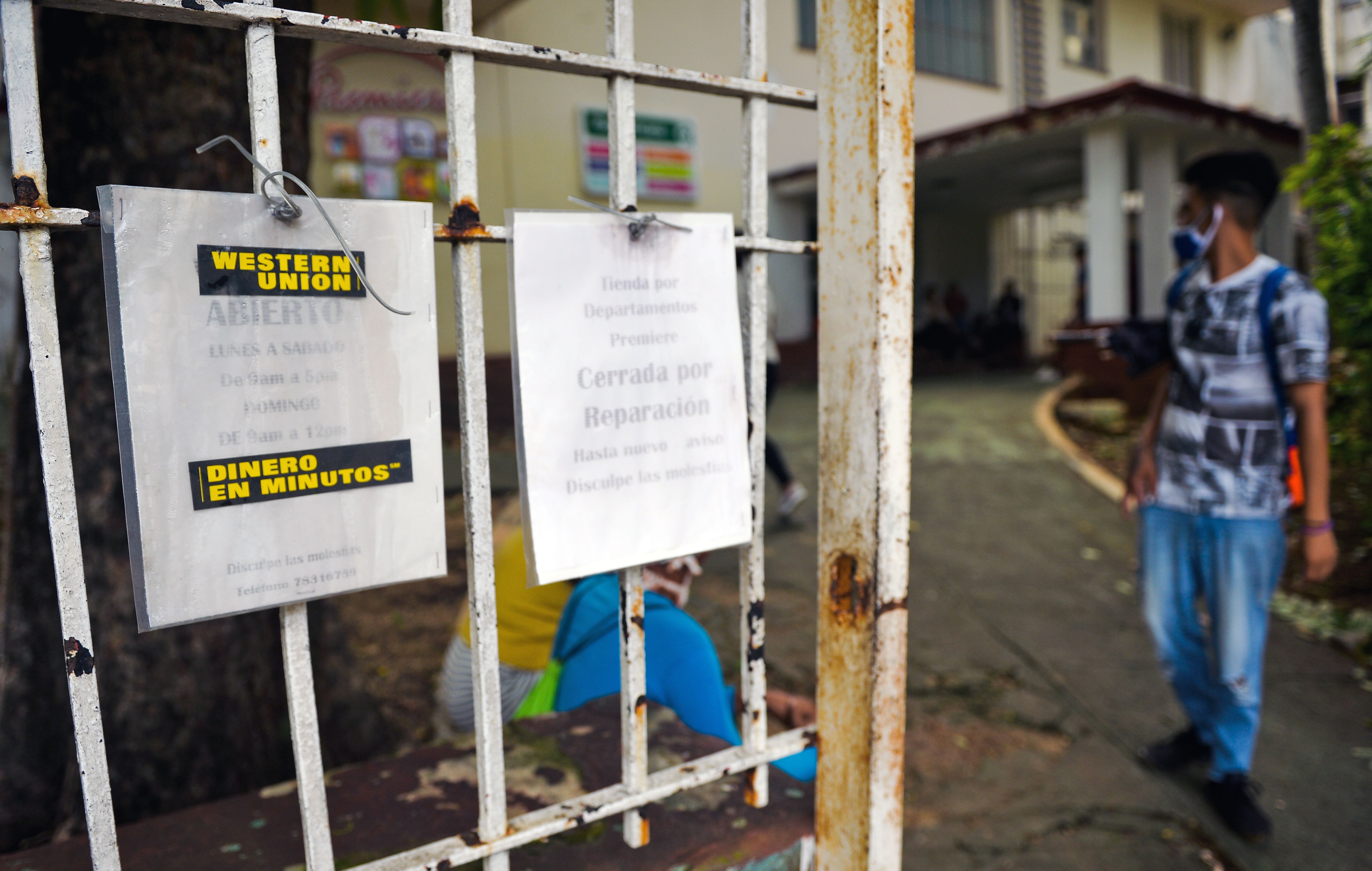 A man walks near notices of Western Union in Havana, as the US-based money transfer company shuts its officers in Cuba after new US sanctions in November.