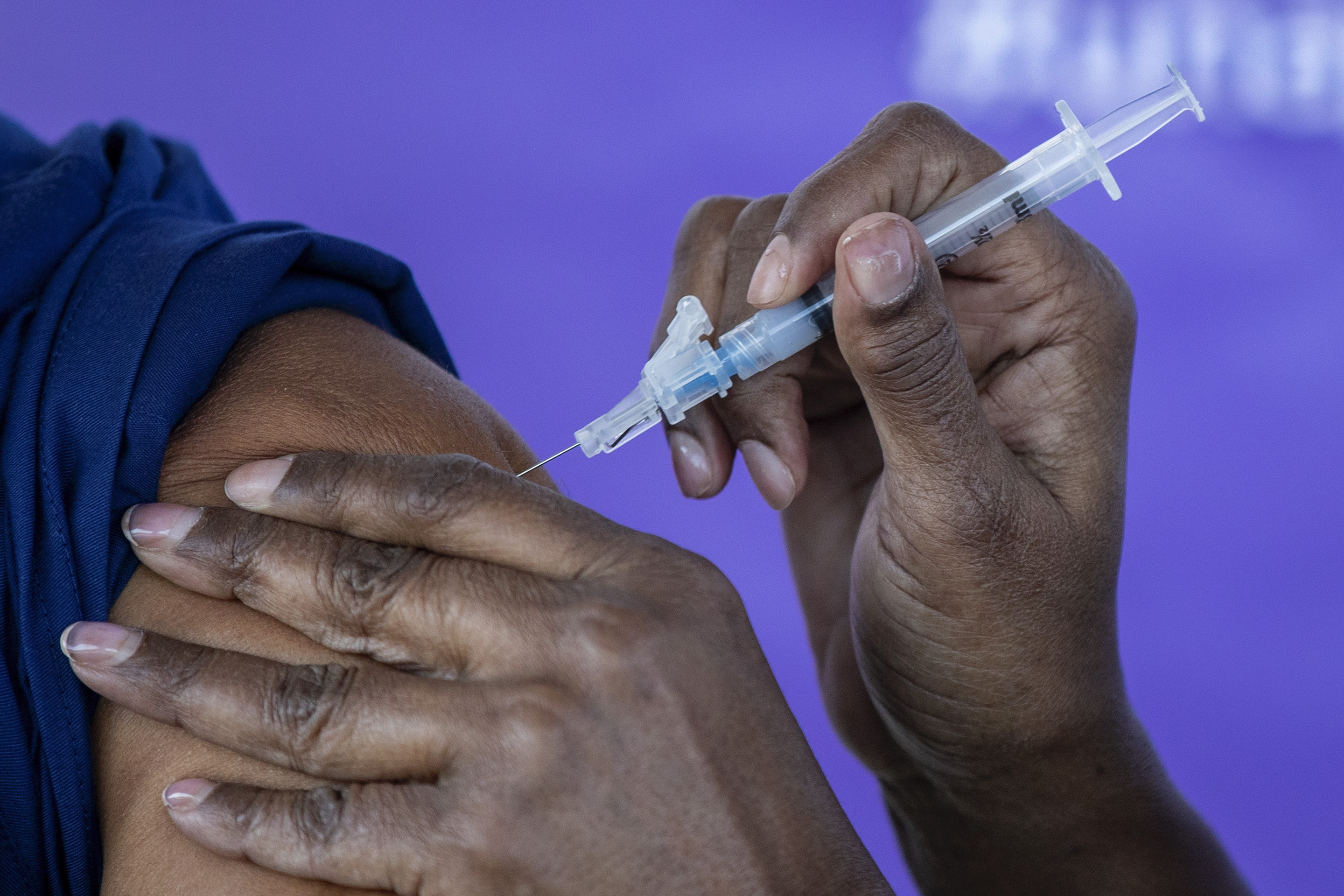 Darlene Dickens-Jeffers, right, senior manager of infection prevention at AltaMed Health Services, gives a Moderna COVID-19 vaccination to former Los Angeles Mayor Antonio Villaraigosa on Jan. 28, 2021.