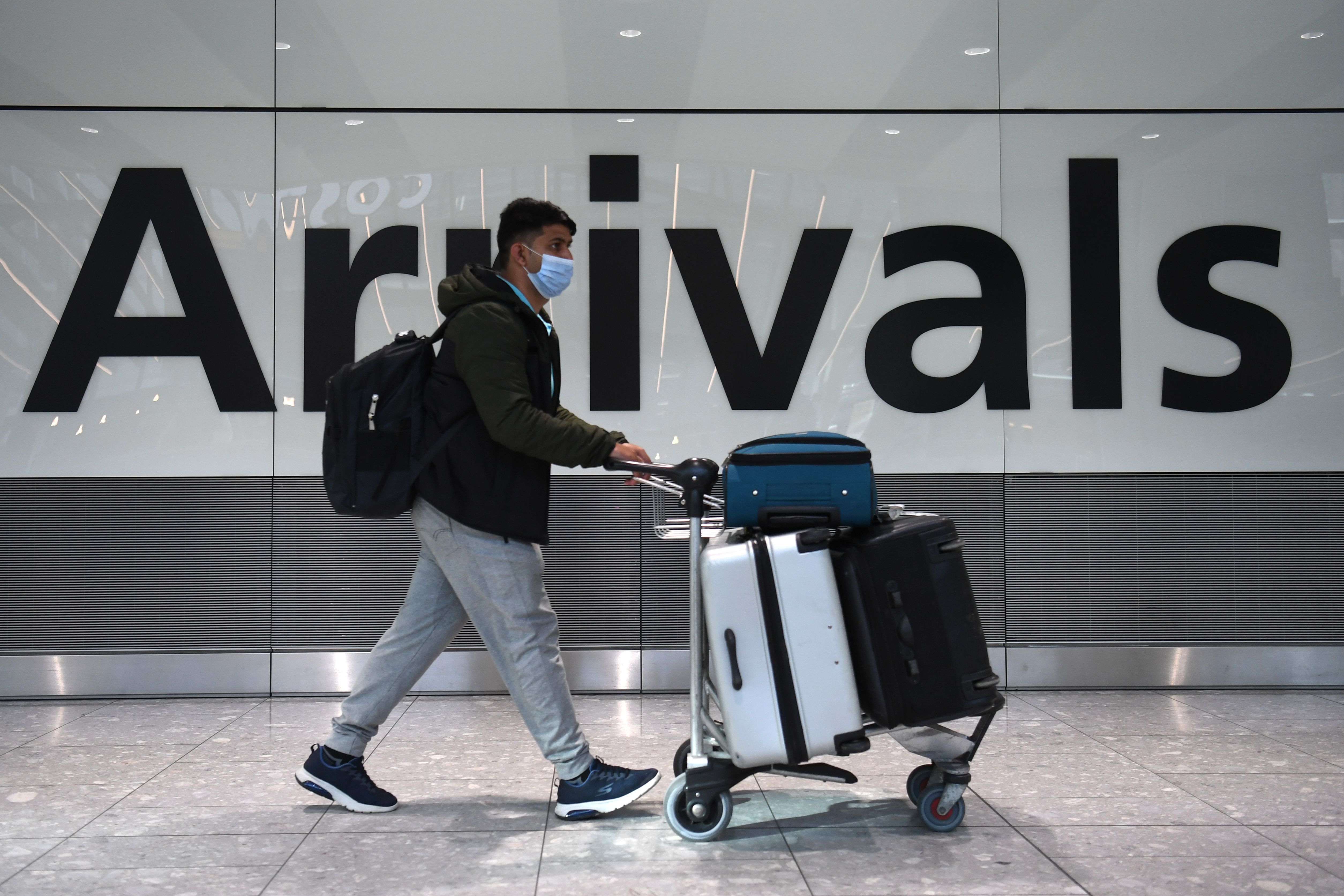A passenger walks through the arrivals hall at Terminal 5, Heathrow Airport in west London on February 15, 2021.