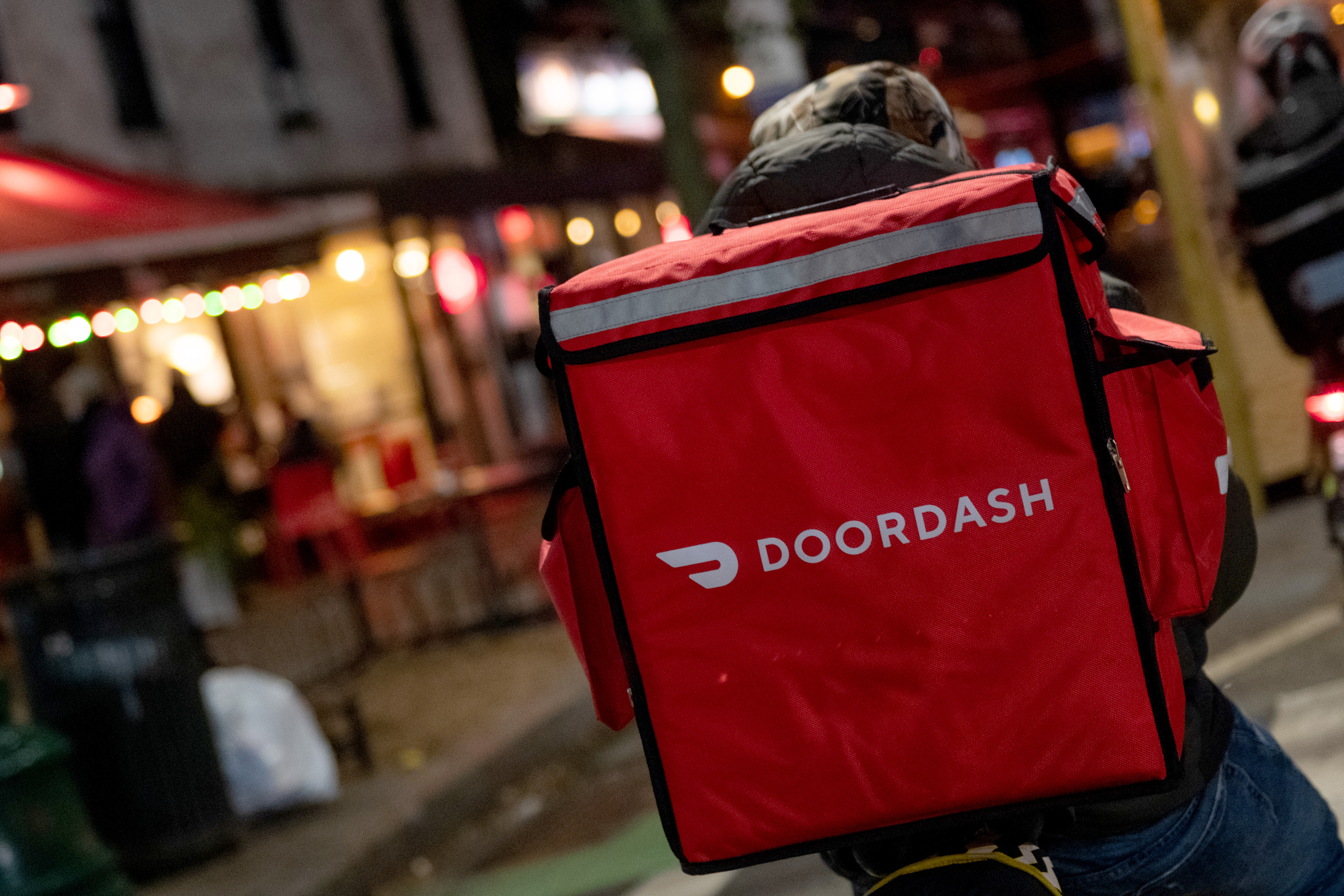 A door-dash delivery driver waits near a restaurant on December 30, 2020 in New York City.