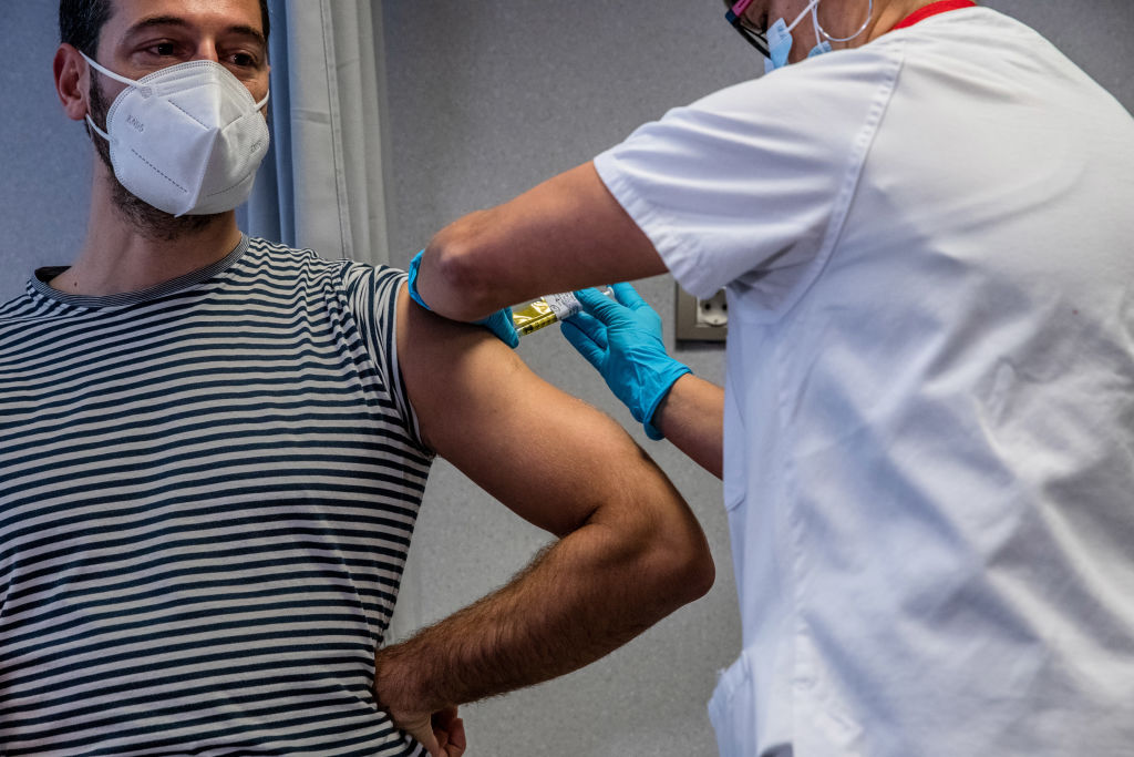 A medical worker administers an injection to a volunteer during a Phase III trial of the Johnson & Johnson COVID-19 vaccine in Barcelona on Dec. 17, 2020.