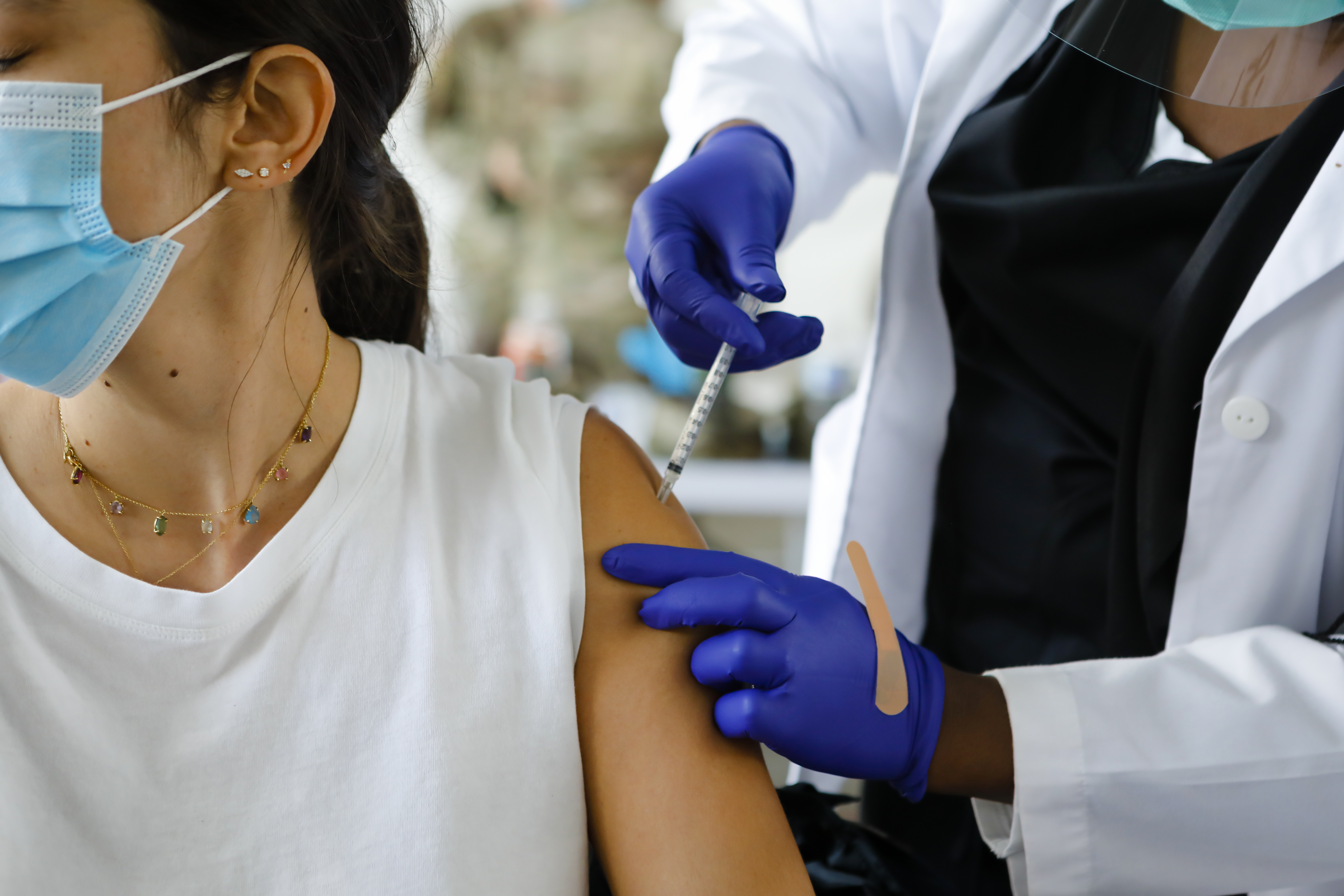 A healthcare administers a dose of the Pfizer-BioNTech Covid-19 vaccine at a vaccination center at the Miami Dade College North Campus in North Miami, Florida.