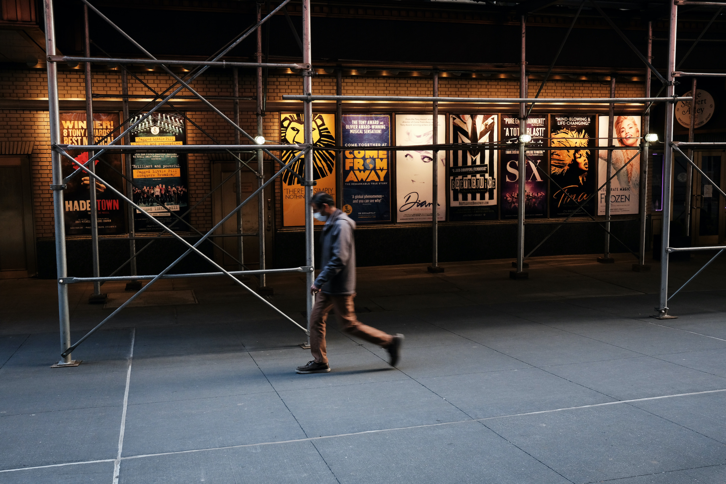 People walk through the empty Broadway theater district one year after it was closed due to Covid-19 restrictions on March 12, 2021 in New York City. Broadway, one of Manhattan’s top tourist attractions and a major financial generator for hotels, restaurants and shopping, is looking to re-open officially in the fall.