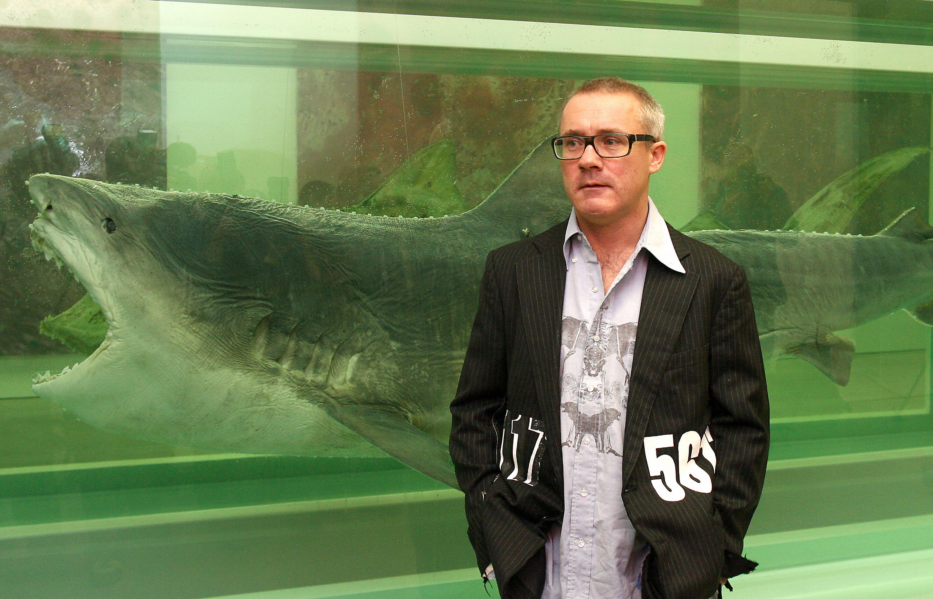 British Artist Damien Hirst with perhaps his most famous work, 1991's "The Physical Impossibility of Death in the Mind of Someone Living." The work, a 13-foot tiger shark preserved in formaldehyde, will not be part of a wave of NFTs offered by Hirst in association with digital art startup Nifty's.