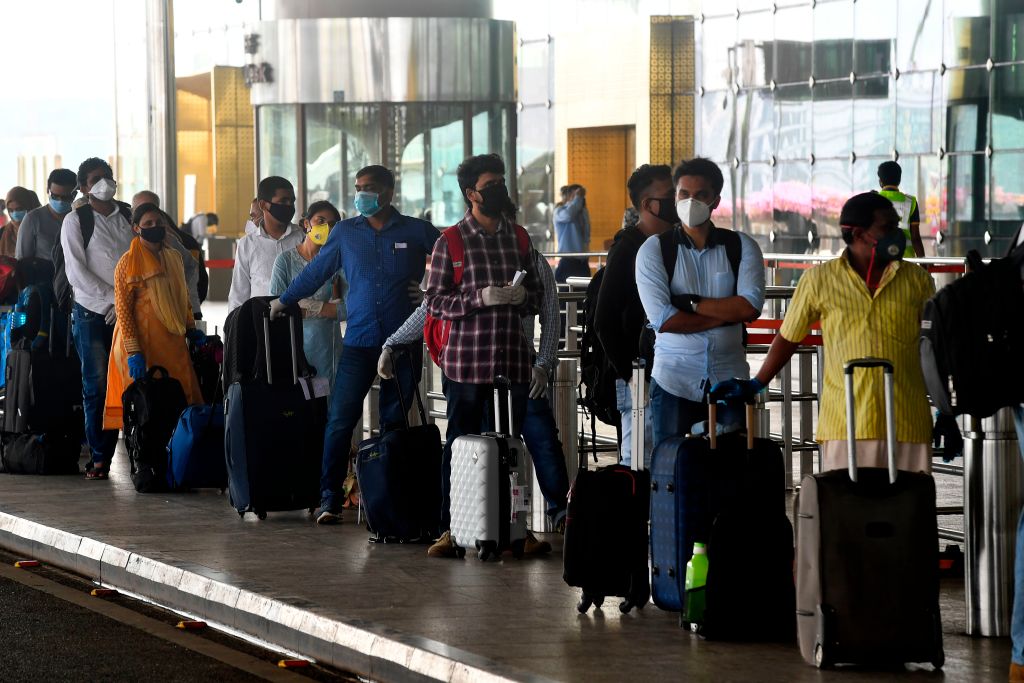 Passengers queue for a departing flight at the airport in Mumbai, on May 25, 2020.