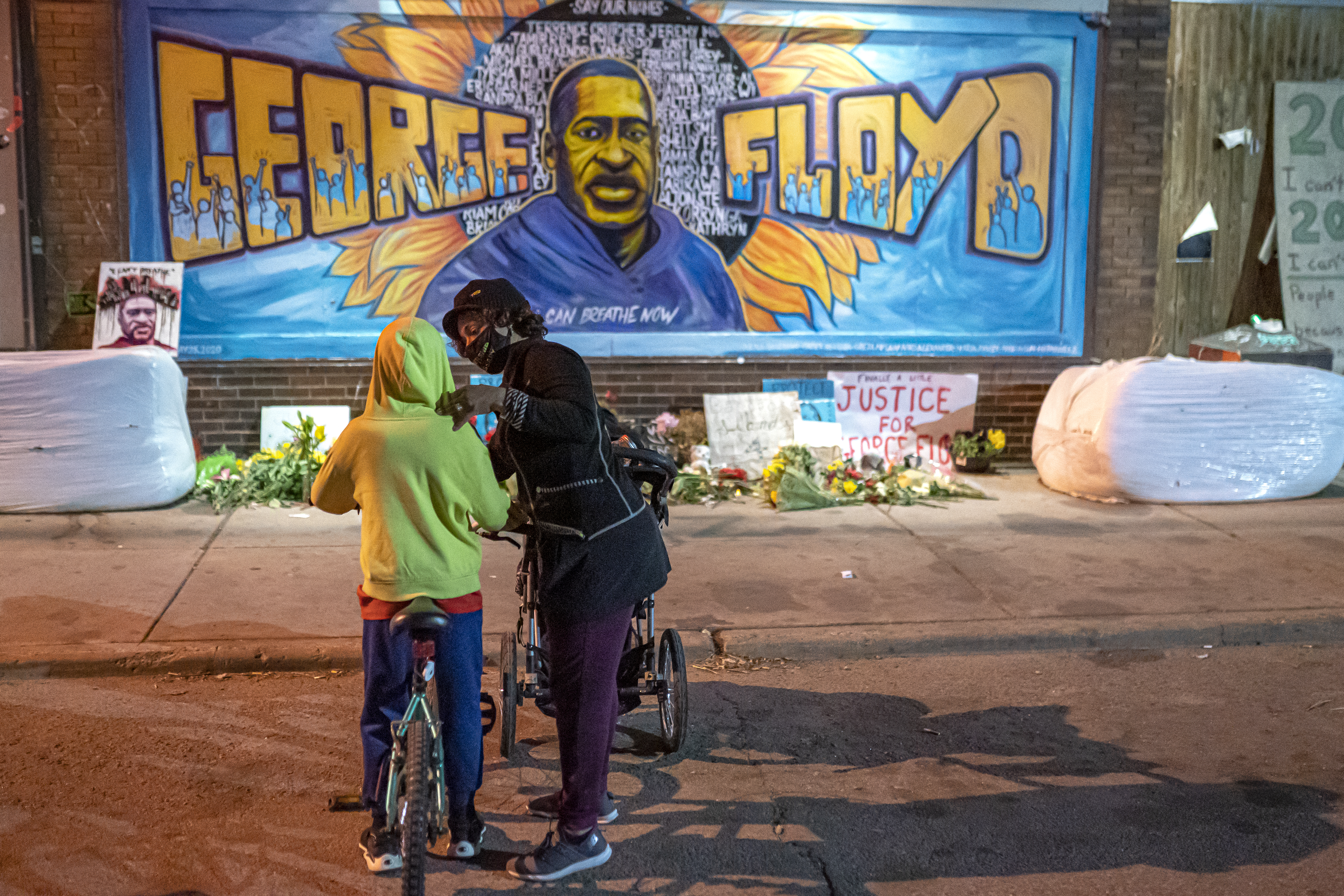 Shannon Haynes talks to her son Ronald Haynes, 9, about George Floyd in front of a memorial following the verdict in the Derek Chauvin trial on April 20, 2021 in Minneapolis, Minnesota.