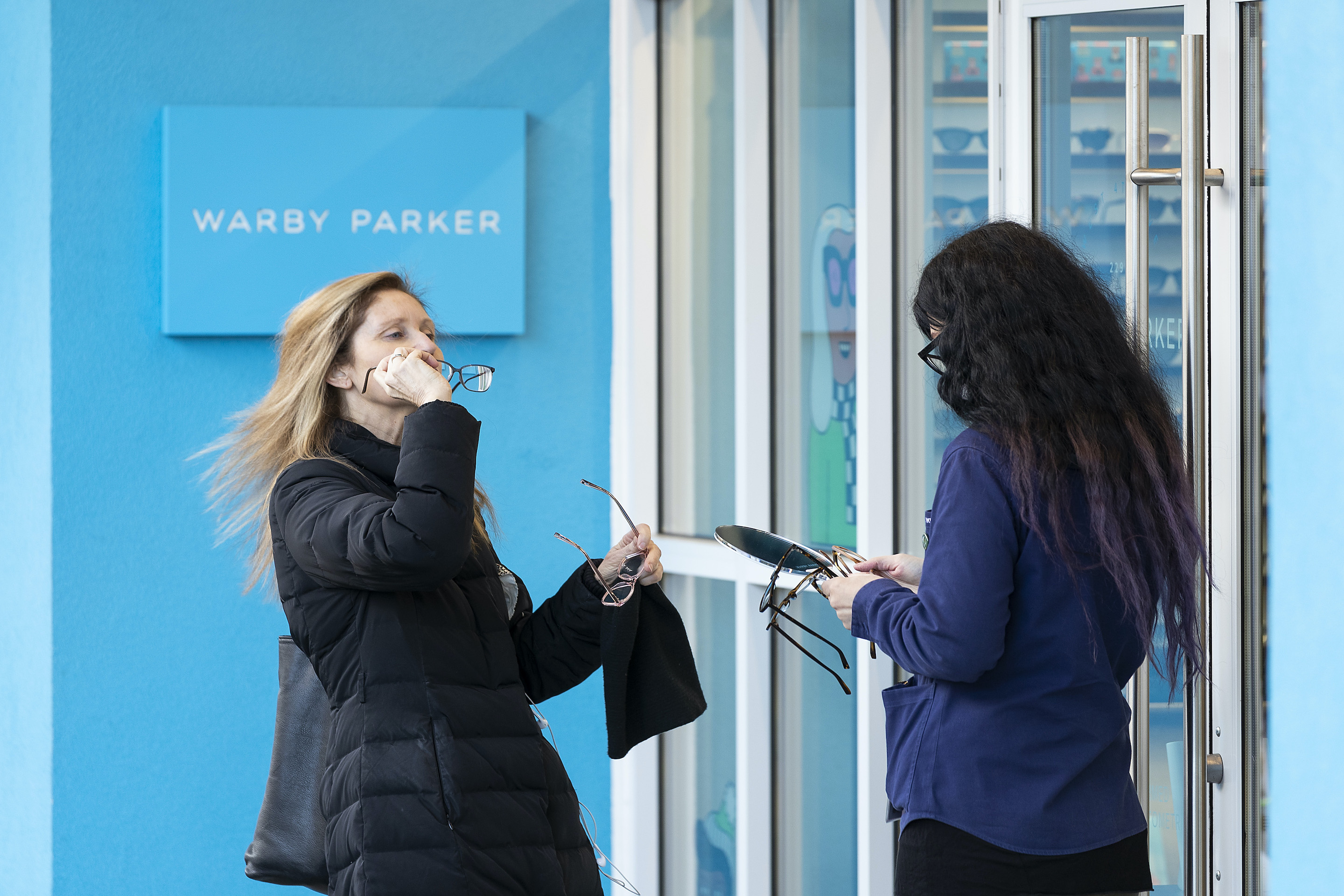 A customer tries on a pair of eyeglasses frames outside a Warby Parker store on November 28, 2020 in Vancouver. 