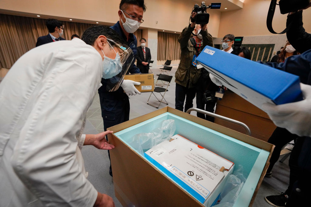 A Tokyo hospital worker checks the temperature of Pfizer COVID-19 vaccines on Feb. 16, 2021.