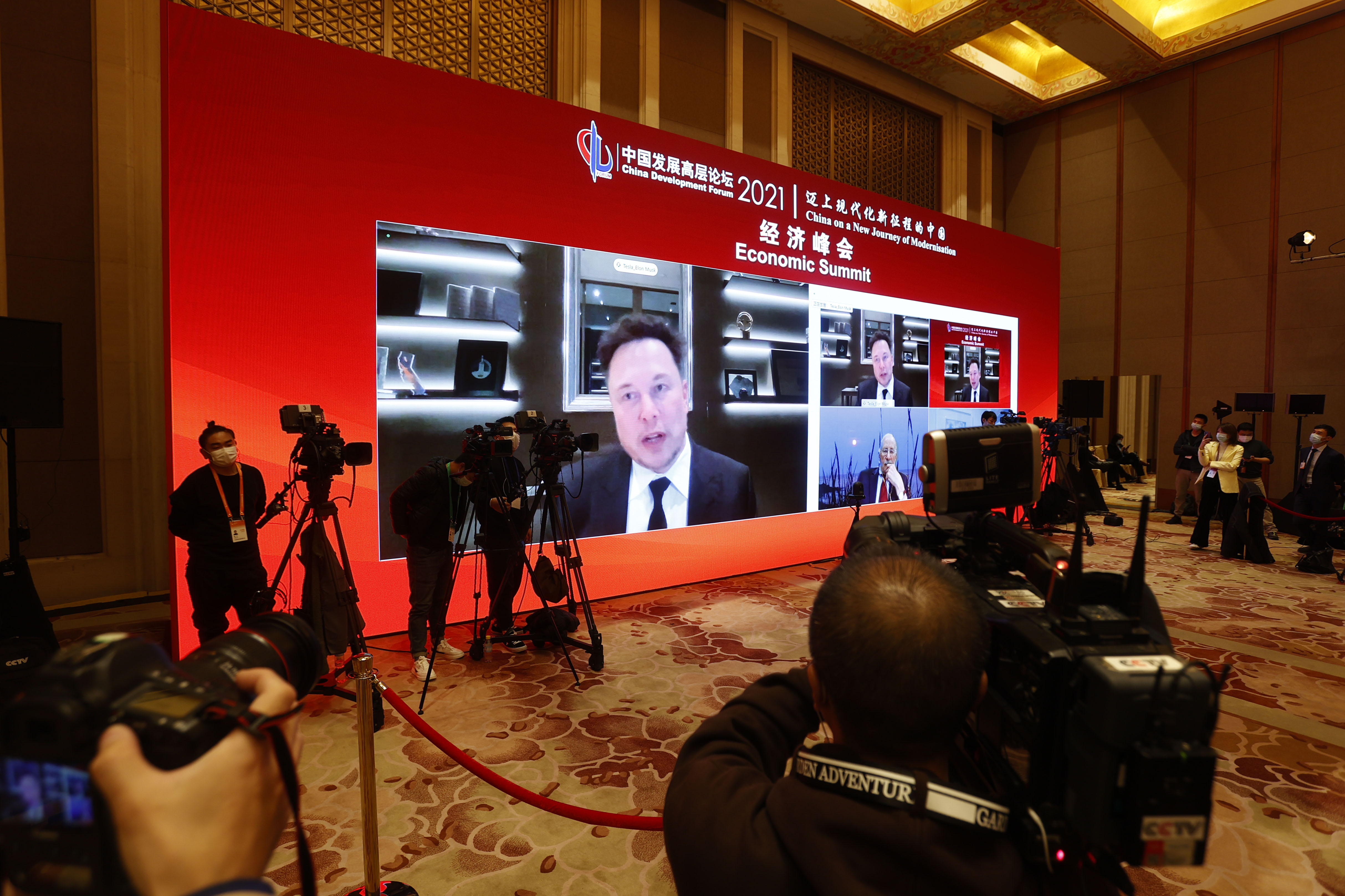 A screen shows Tesla CEO Elon Mask speaking via video link during the 2021 China Development Forum at Diaoyutai State Guesthouse on March 20, 2021 in Beijing.