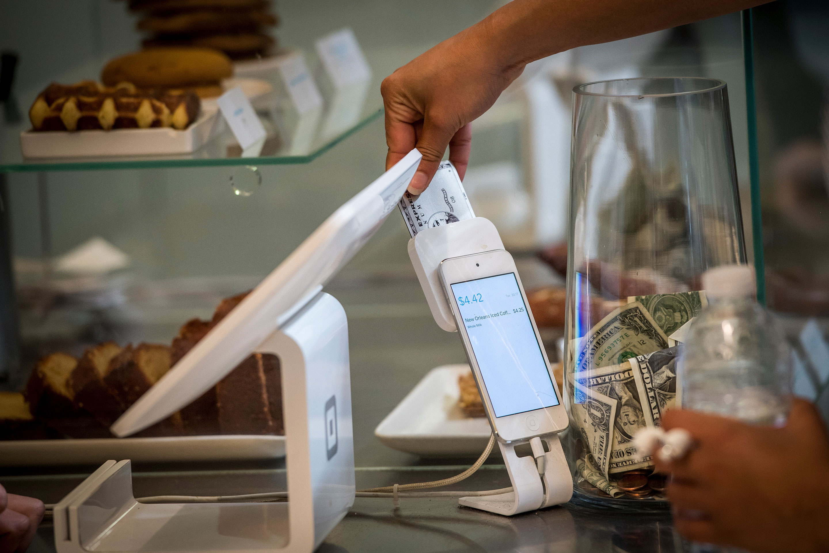 A customer inserts a credit card into a Square device to make a payment.