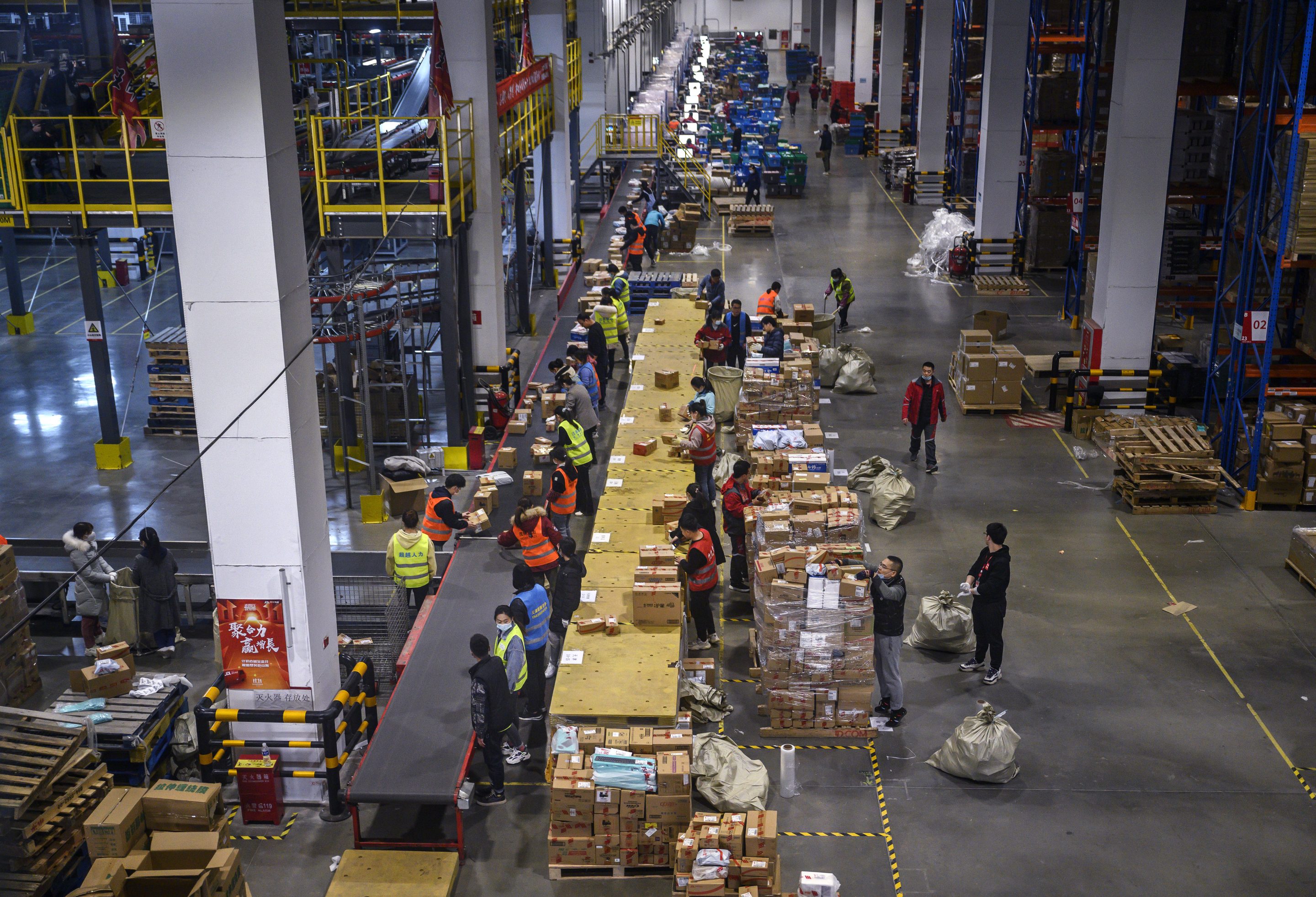 Workers from Chinese e-commerce giant JD.com work in the warehouse at the company's main logistics hub during an organized tour for Singles Day on November 11, 2020 in Beijing, China.