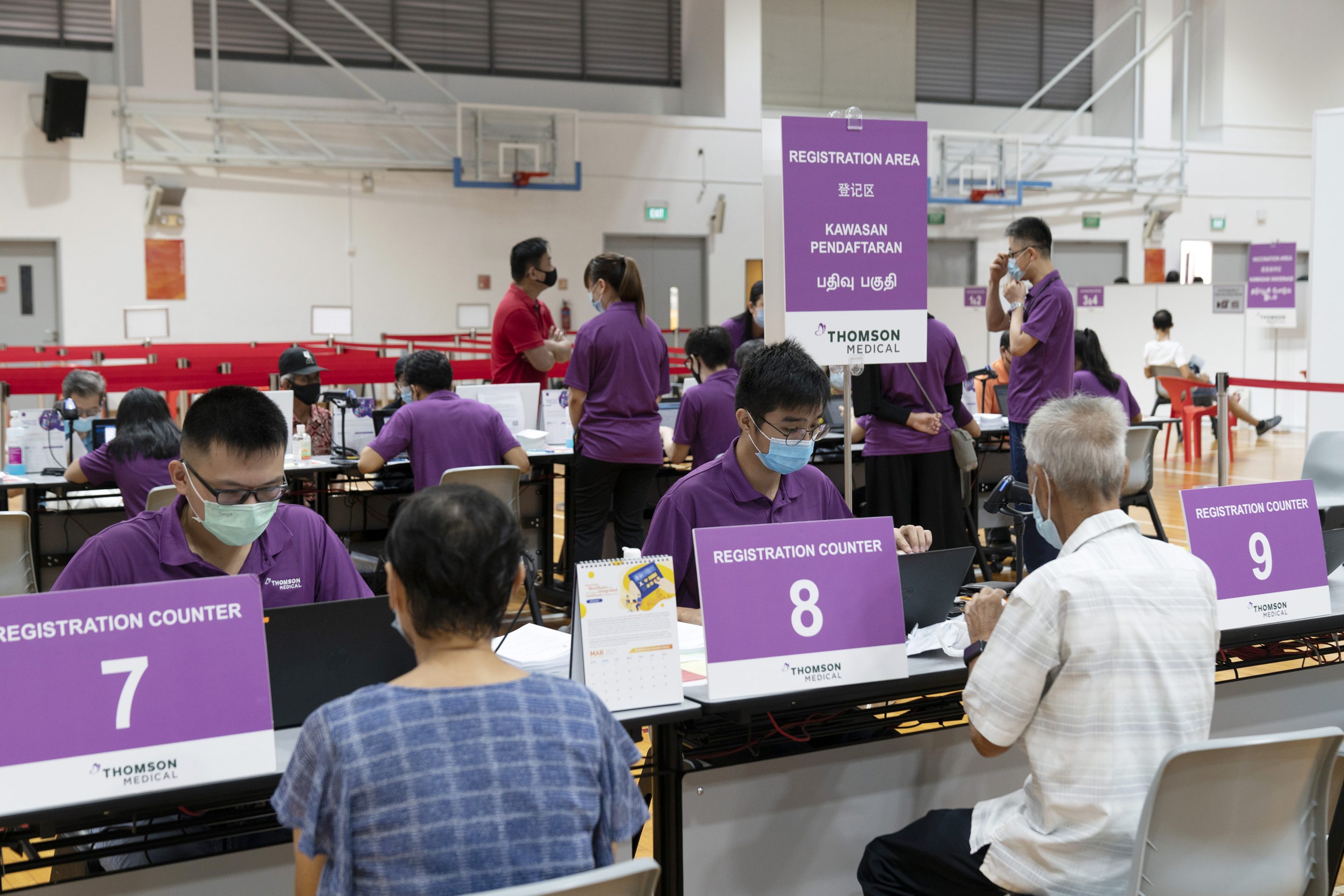 Health workers assist senior citizens registering for the Pfizer-BioNTech Covid-19 vaccine at the Senja-Cashew Community Centre Vaccination Centre, operated by Thomson Medical, in Singapore on March 8, 2021.