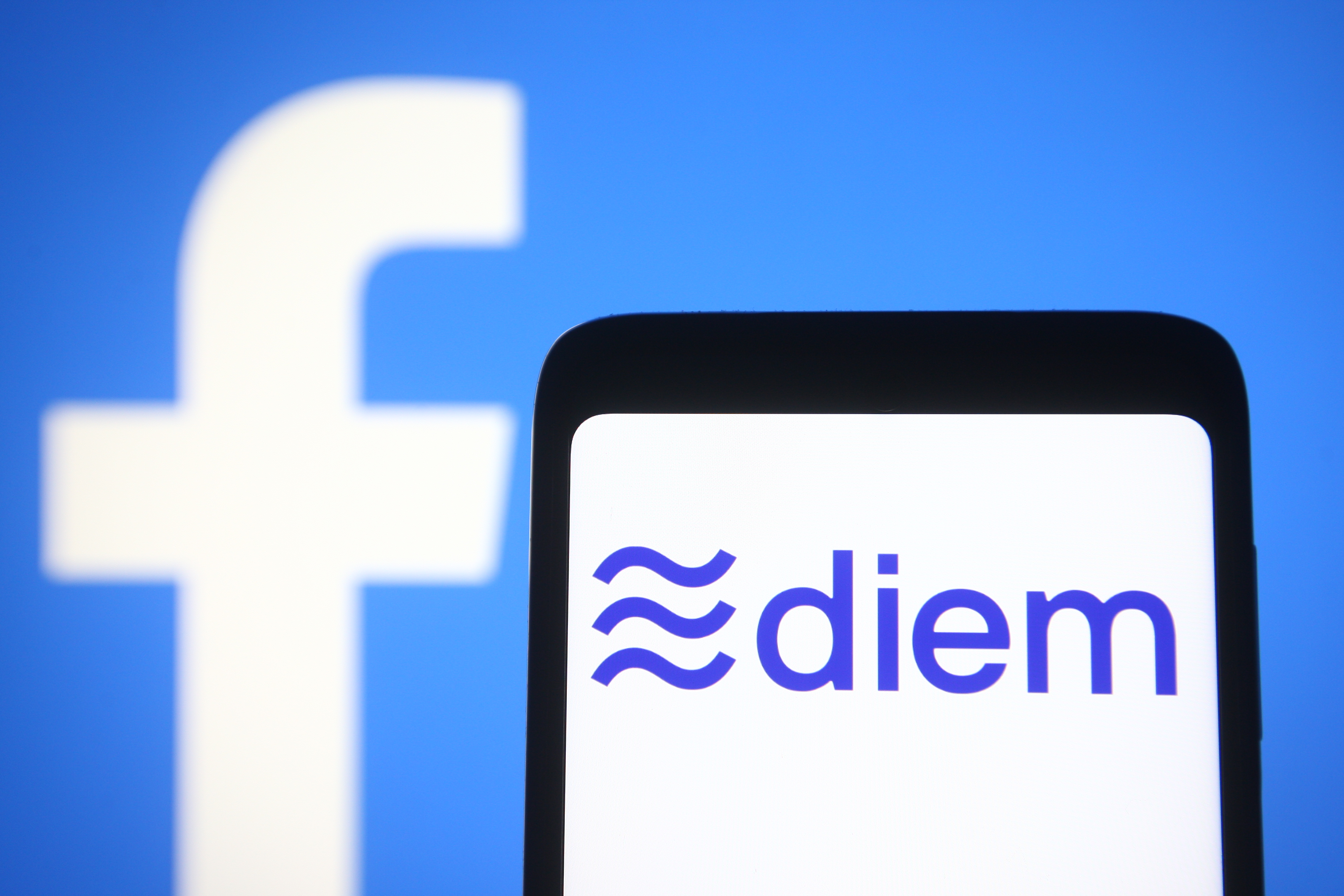 In this photo illustration the Diem, formerly known as Libra, logo is seen is seen on a smartphone screen with a Facebook logo in the background.