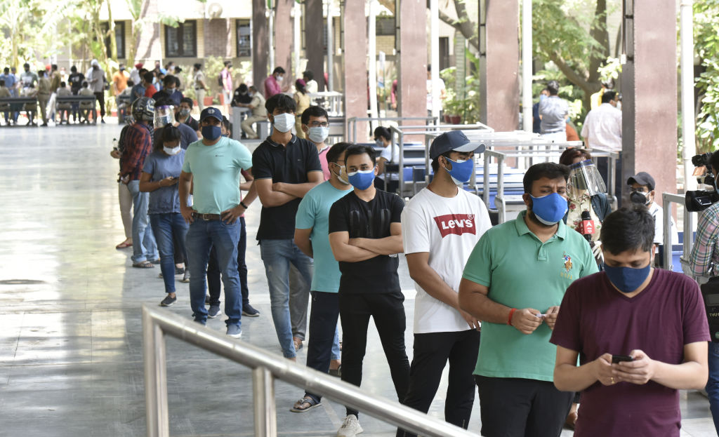 People in the 18 to 44 age group queue for the COVID-19 vaccine at a school in New Delhi, on May 3, 2021.