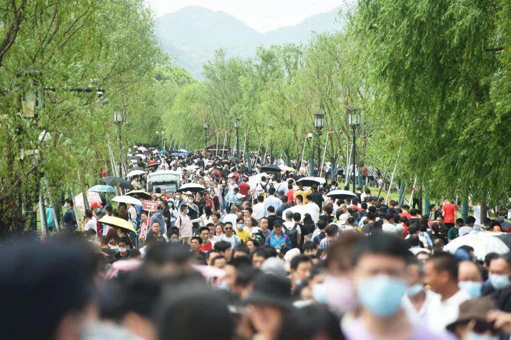 Tourists crowd an ancient bridge at the West Lake in Hangzhou in Zhejiang province, on May 1, 2021.
