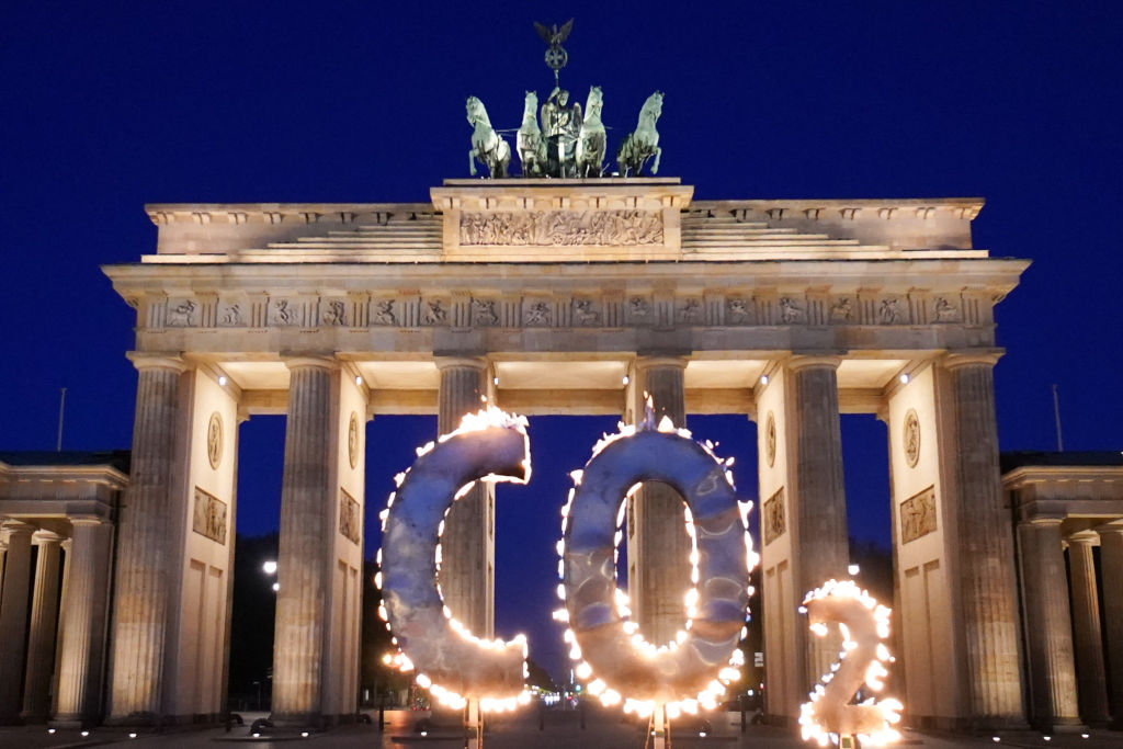 In a Greenpeace action, a CO-2 sign stands in front of the Brandenburg Gate with flames coming out of it. With the action, activists of the environmental protection organization Greenpeace call on the German government to further reduce CO-2 emissions in Germany and to ensure compliance with the goals of the world climate summit in Paris.