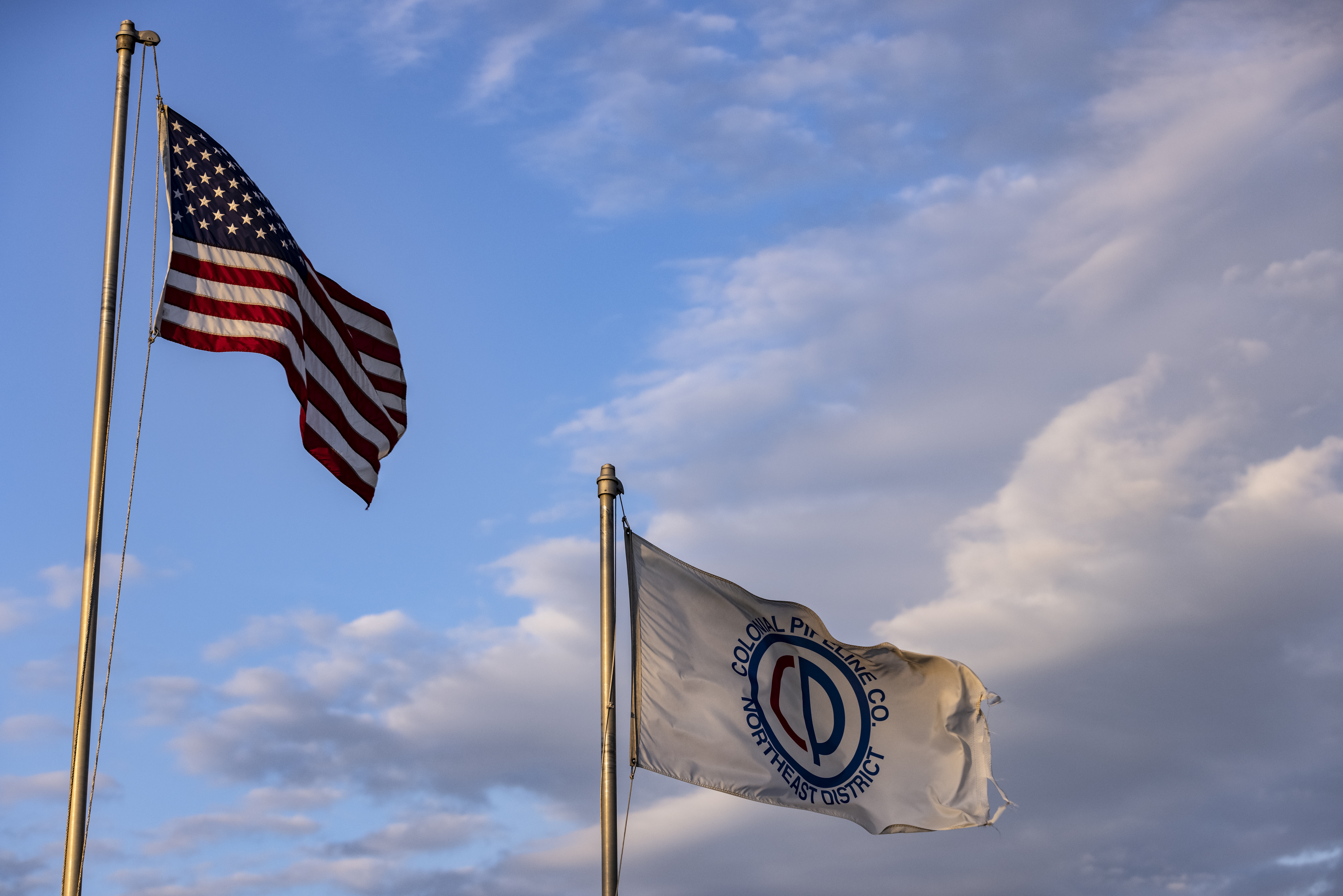 An American flag and a company flag fly at Colonial Pipeline Co. facility in the Port of Baltimore in Baltimore, Maryland on May 11, 2021.