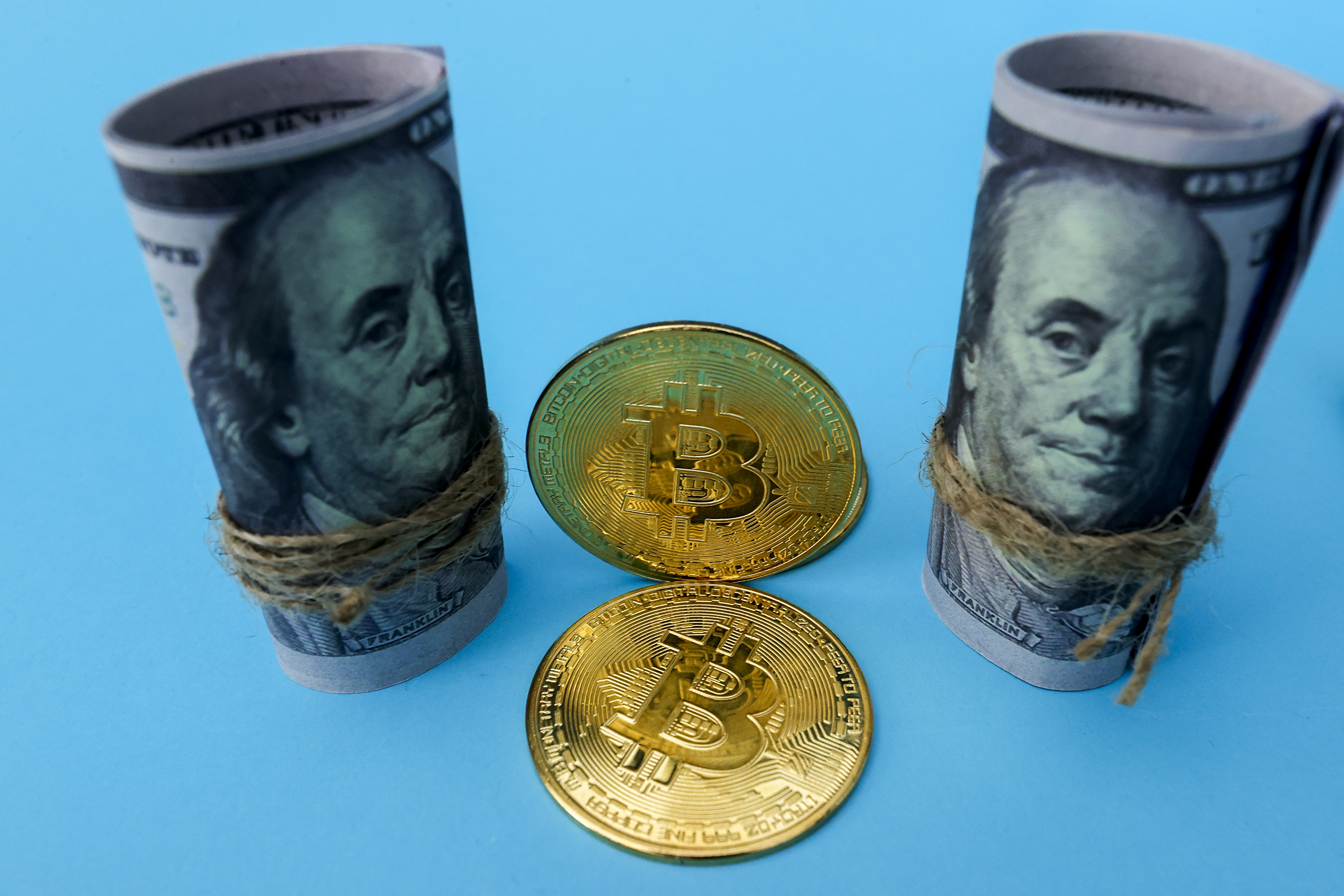In this photo golden Bitcoin cryptocurrency and US dollars are seen in Antalya, Turkey on May 13, 2021. (Photo by Mustafa Ciftci/Anadolu Agency via Getty Images)