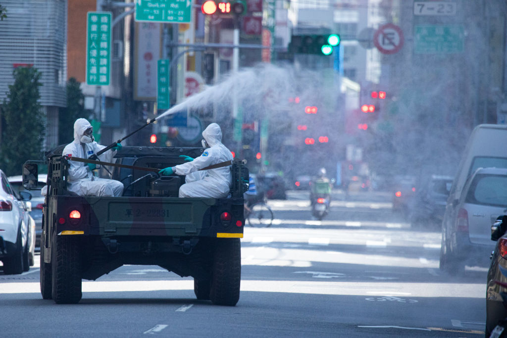 Workers disinfect the streets of Taipei as the Taiwanese capital grapples with a surge in COVID-19 cases.