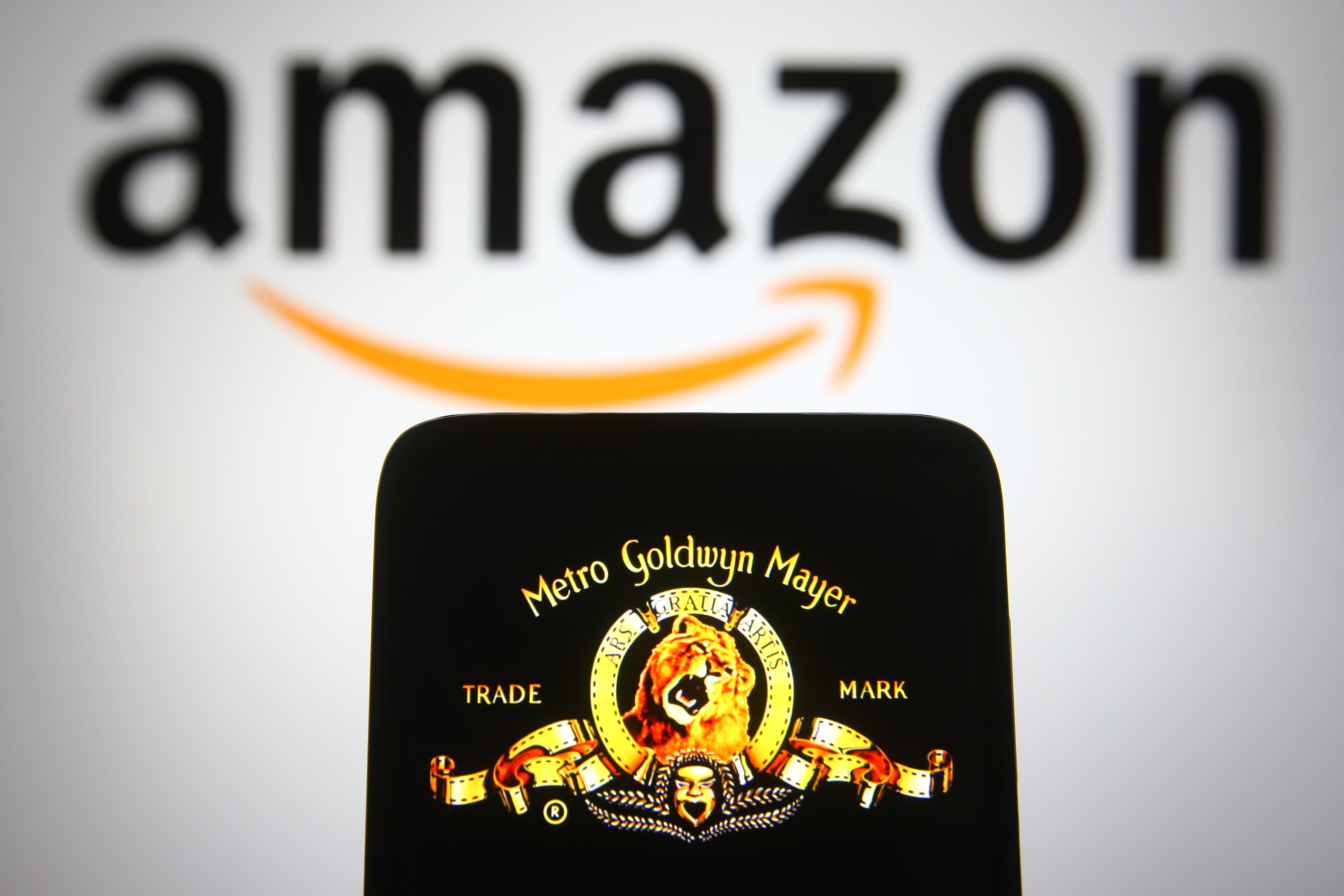 In this photo illustration the Metro-Goldwyn-Mayer (MGM) logo of US media company is seen on a smartphone screen with an Amazon logo in the background.